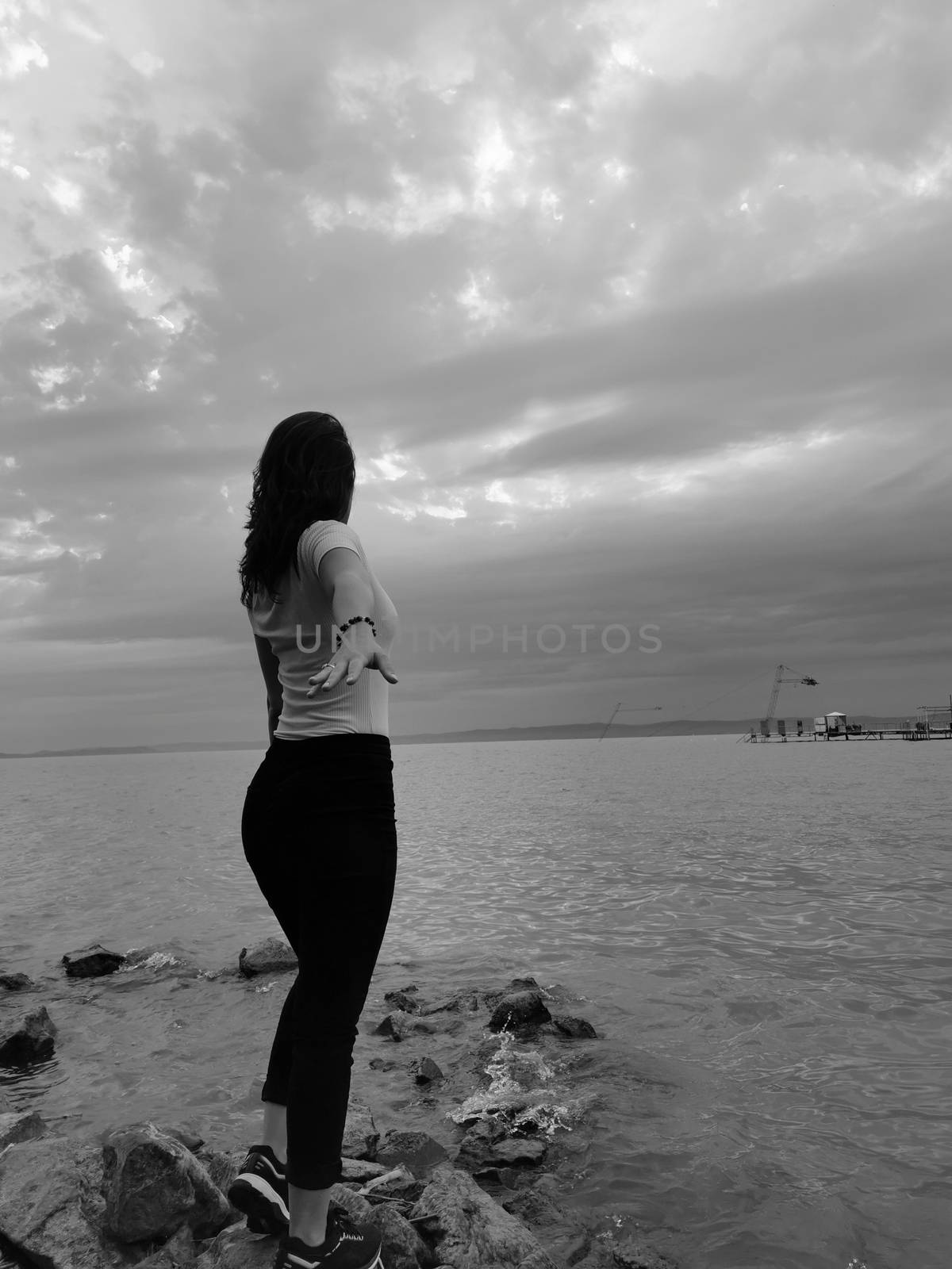 A person standing next to a body of water. High quality photo