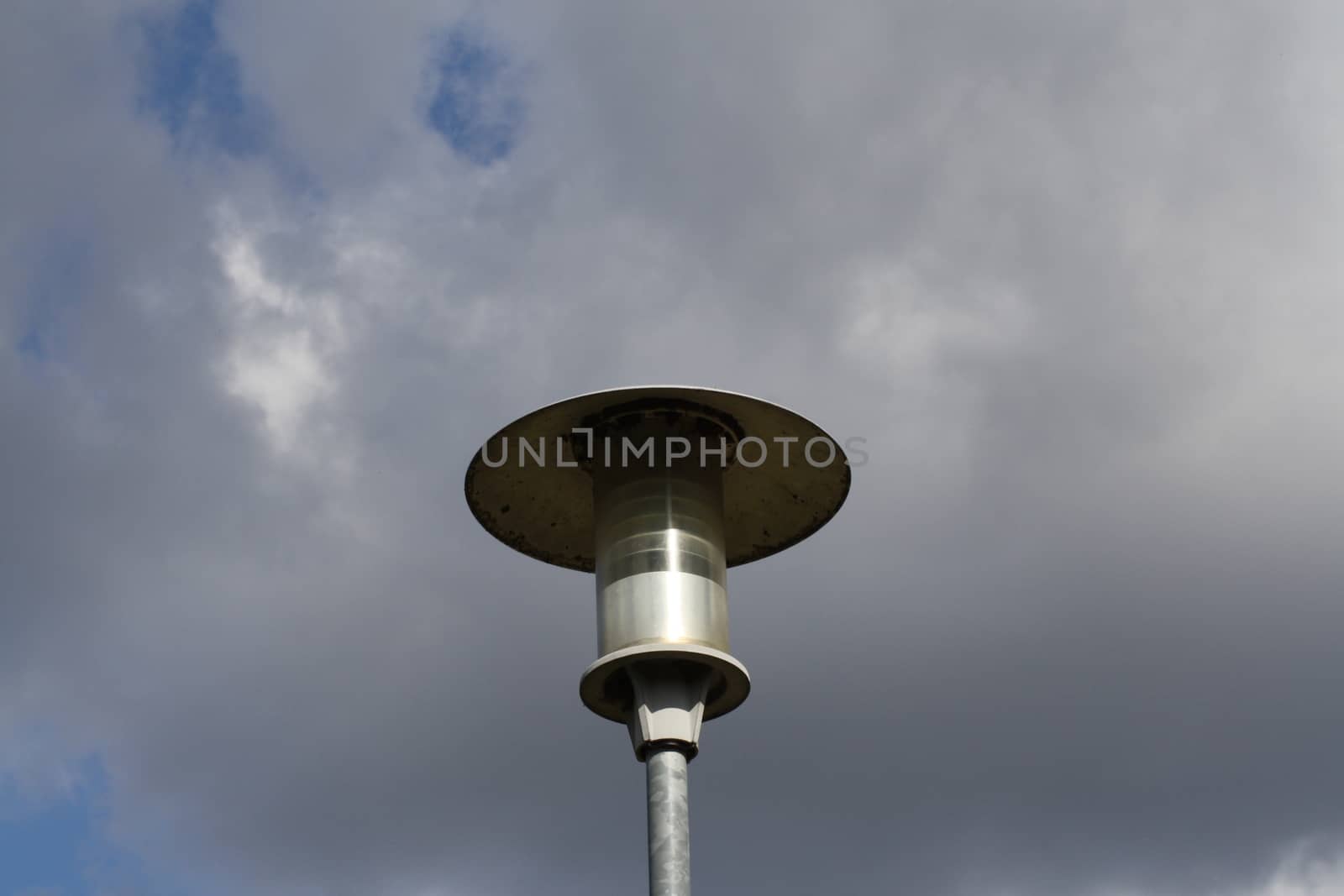 A close up of a street lamp in front of a cloudy sky. High quality photo