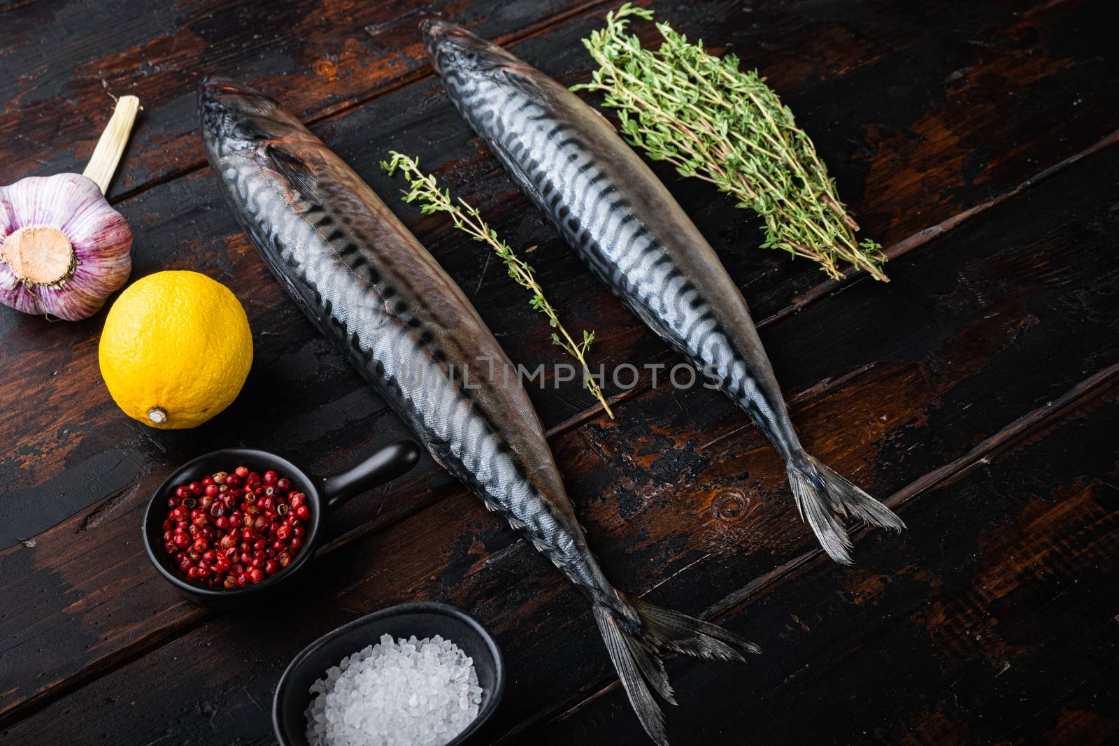 Mackerel with herbs on dark wooden background.