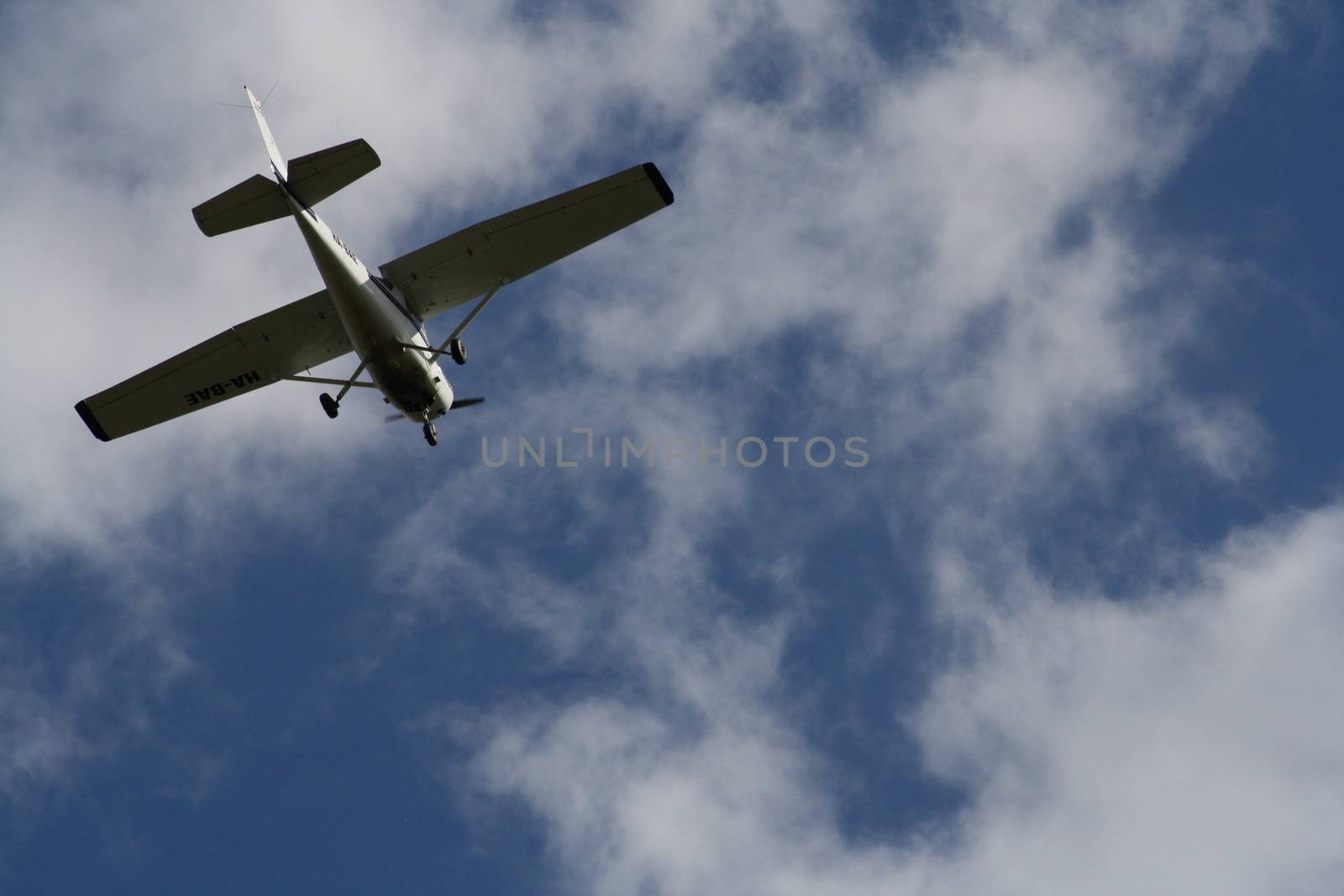 A plane flying through a cloudy blue sky. High quality photo