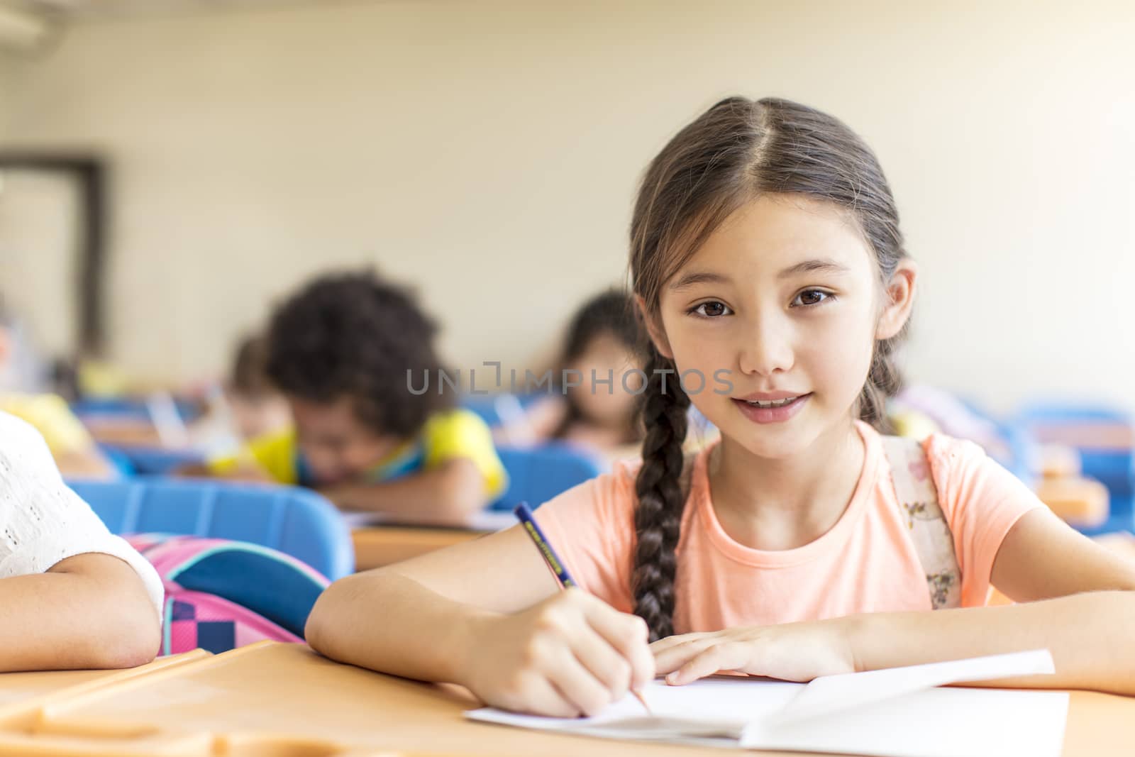 beautiful little girl studying in the classroom. by tomwang
