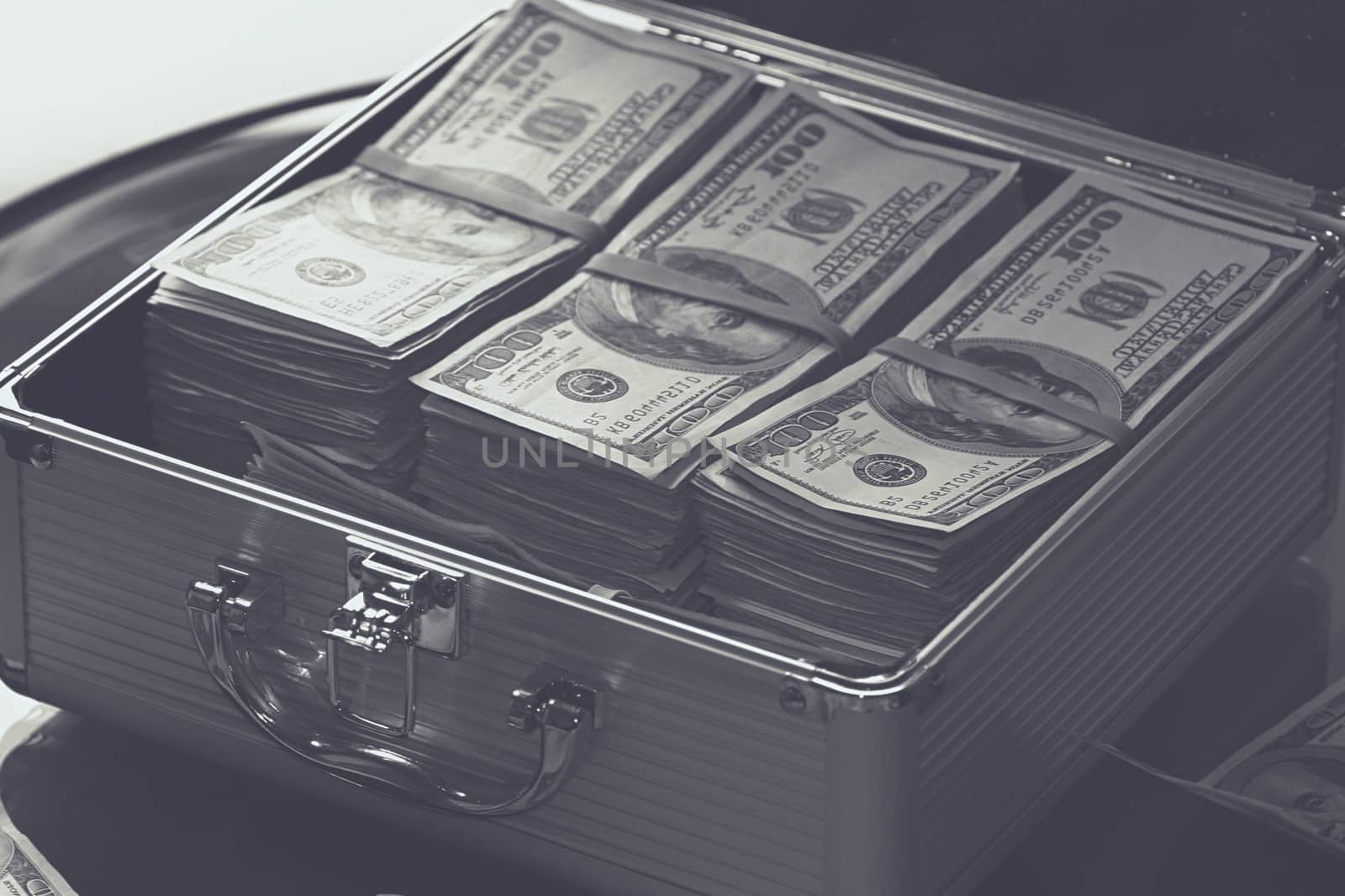 Suitcase full of dollar notes on a black background. High quality photo