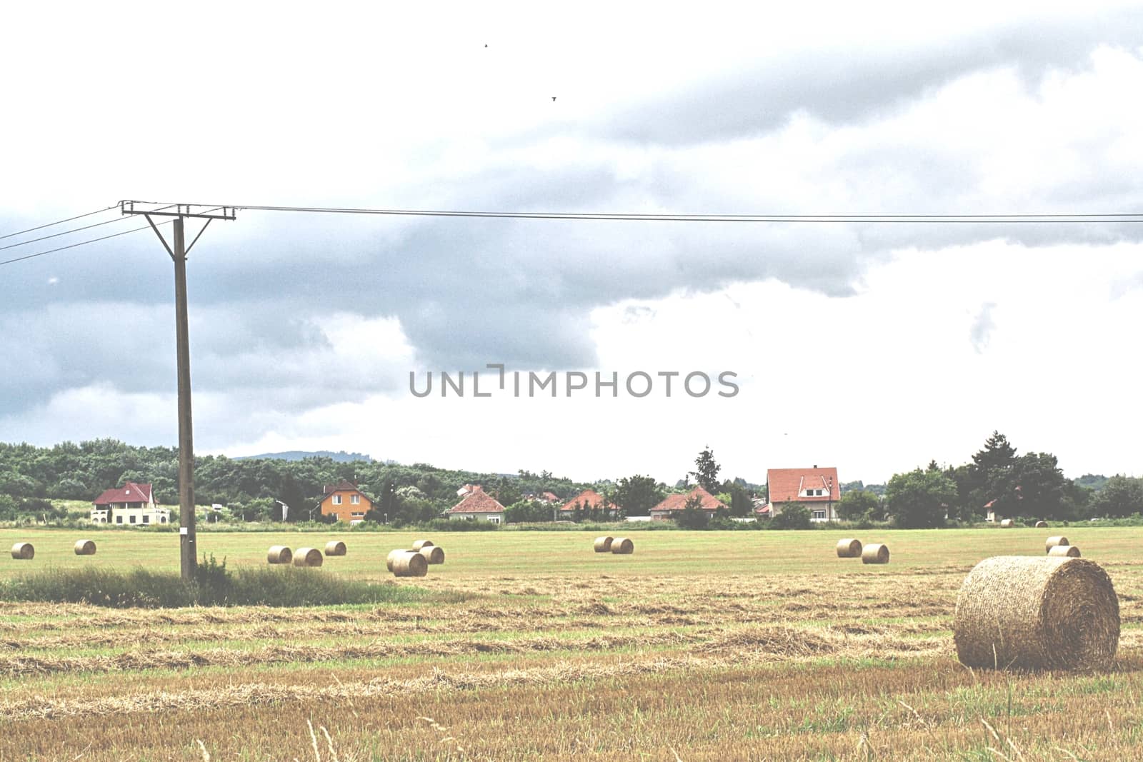 Straw bales on the outskirts of Miskolc in the great field with houses and overturned skies. High quality photo