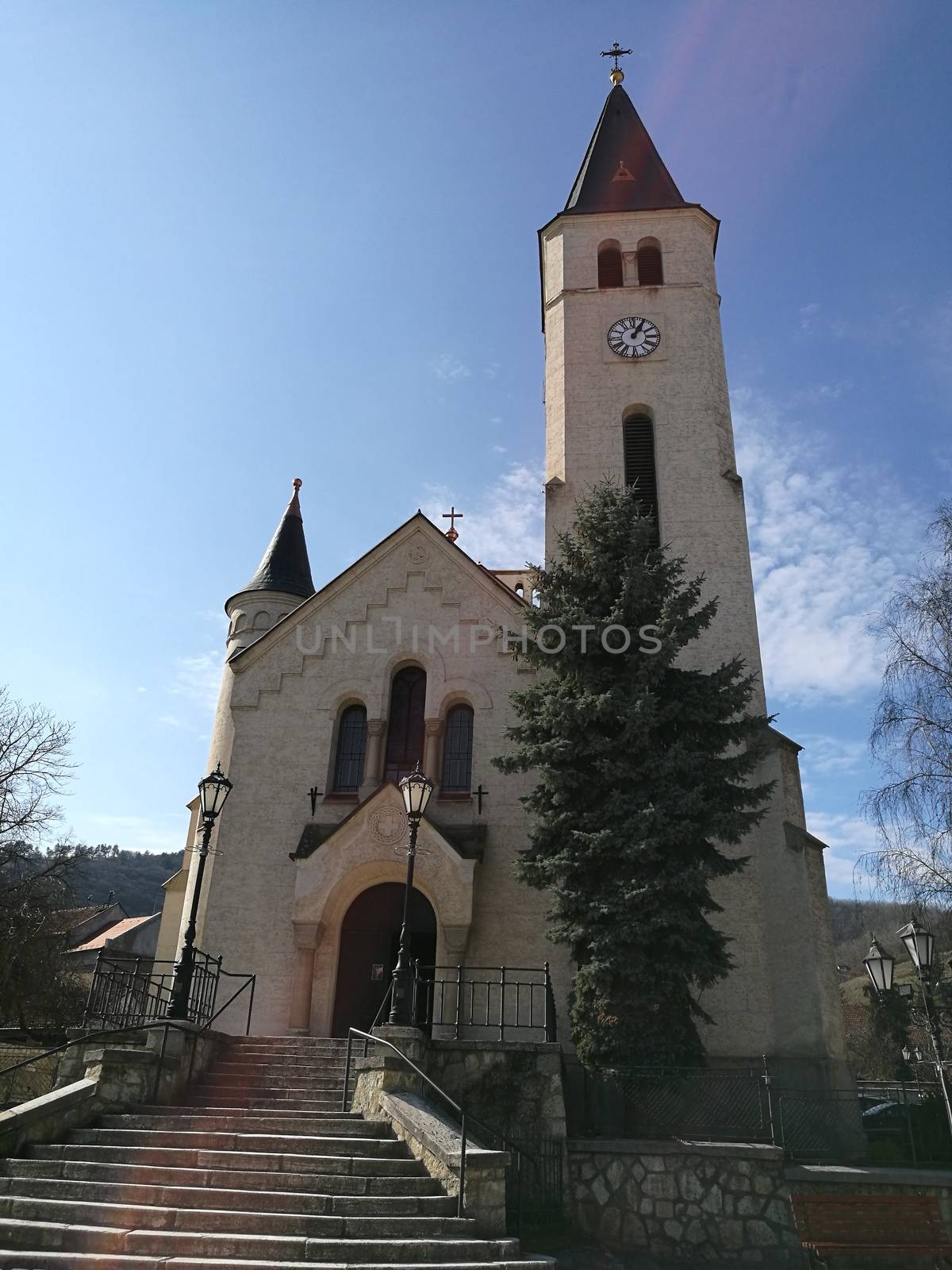 A church with a clock tower in front of a brick building. High quality photo