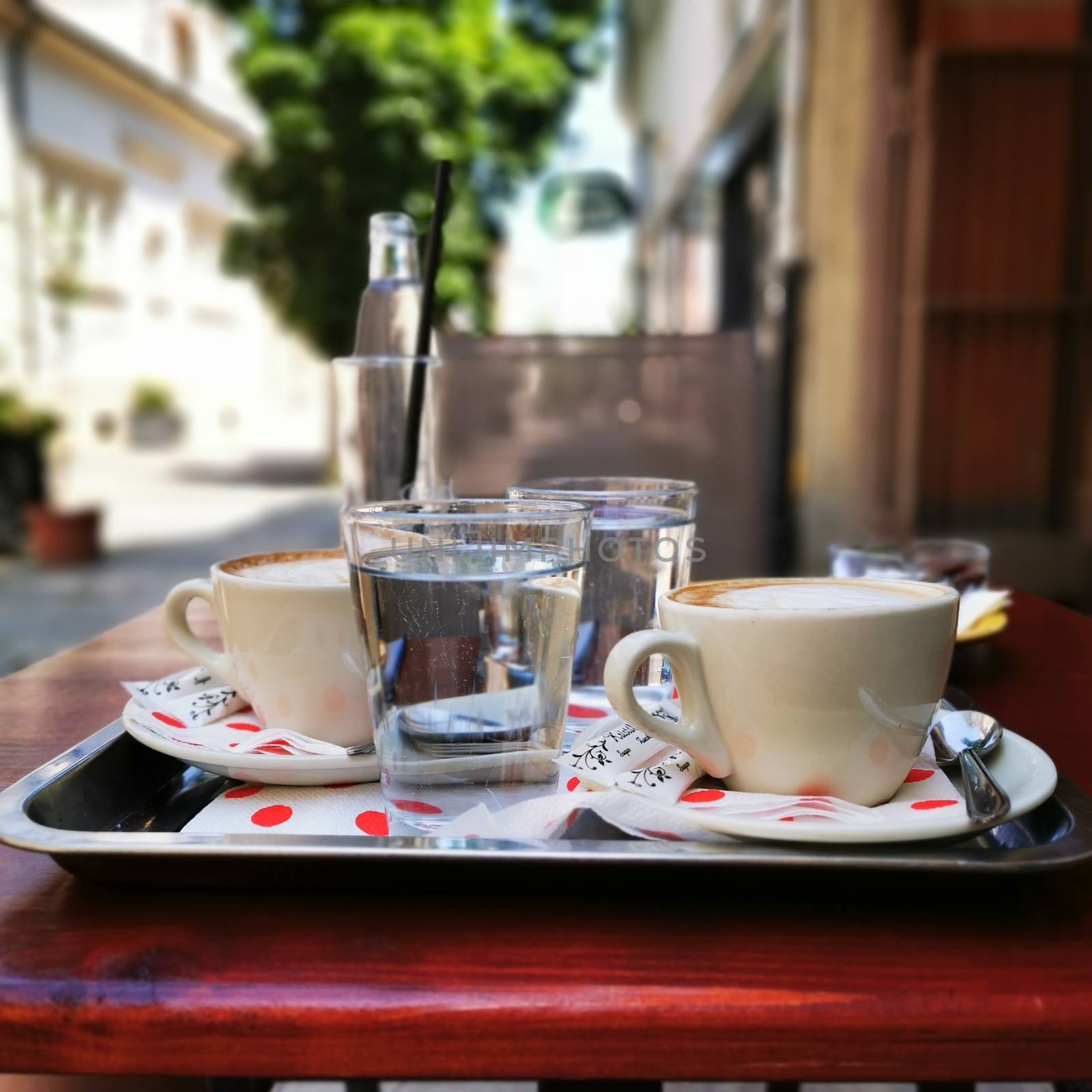 A cup of coffee and a mineral water on a table. High quality photo