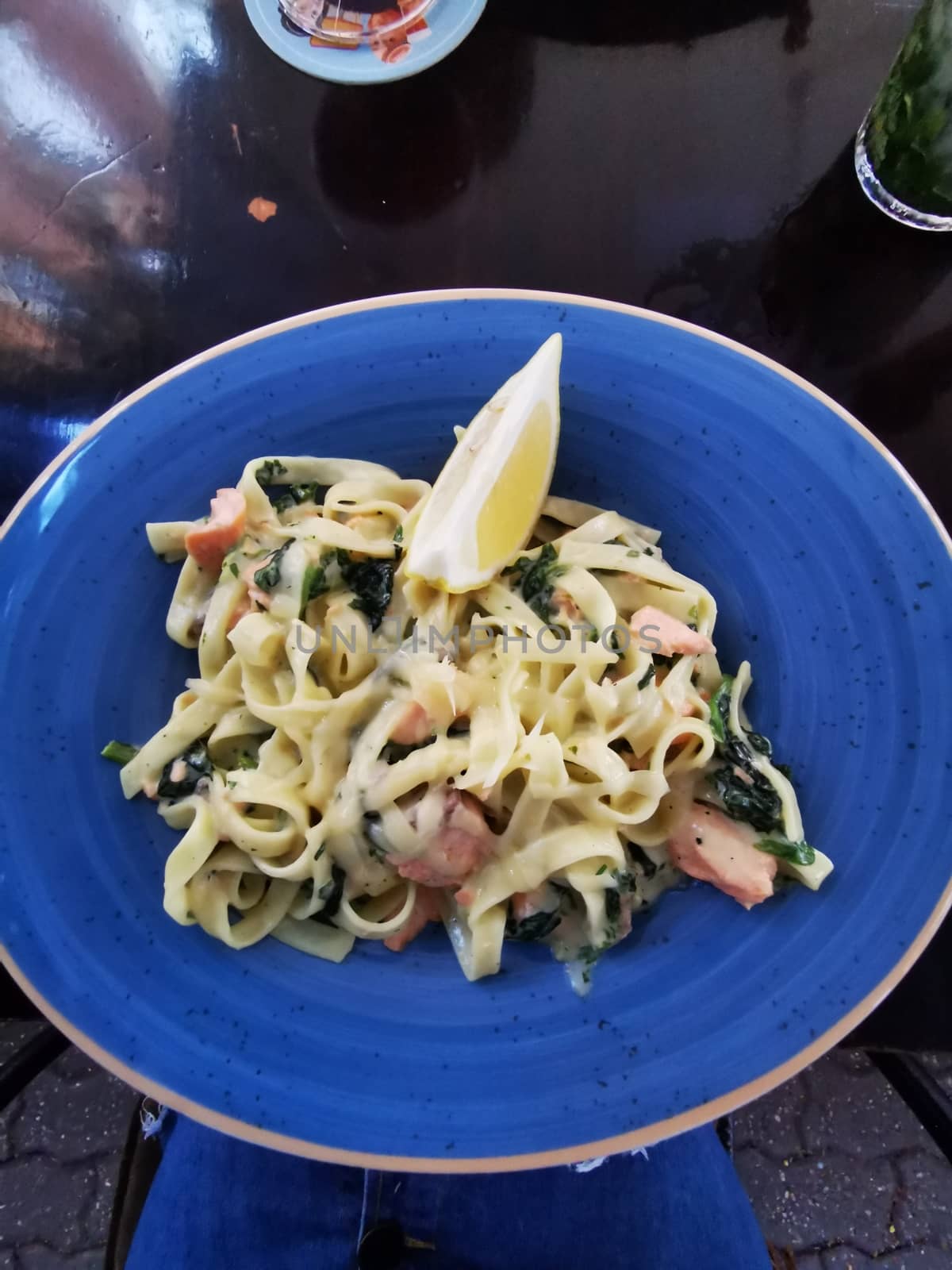 A bowl of pasta salad on a blue plate. High quality photo