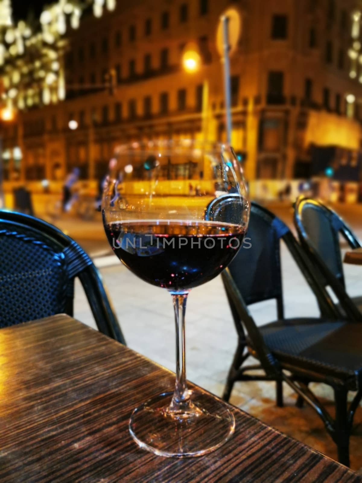 A glass of wine sitting on top of a wooden table. High quality photo