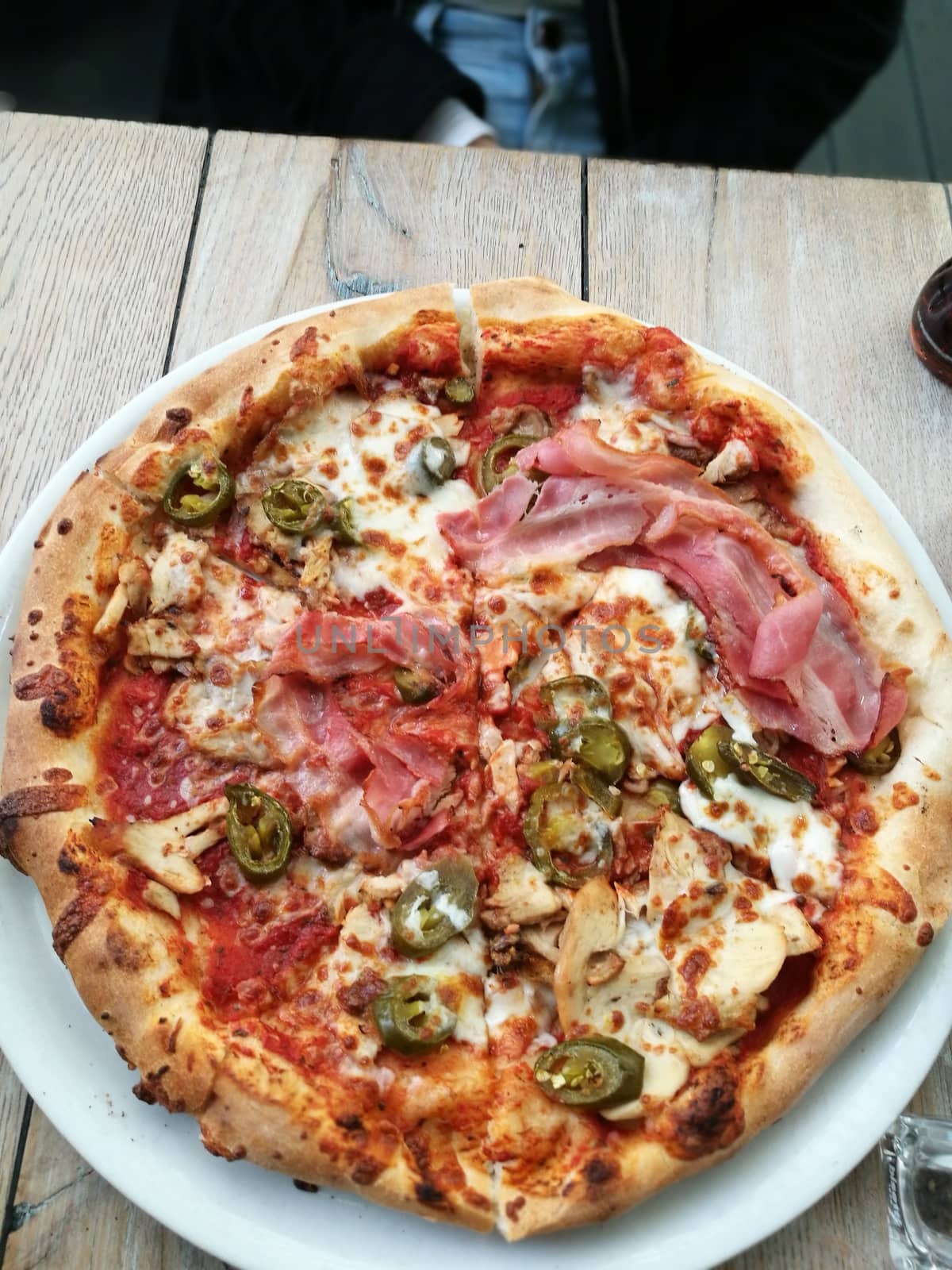 A pizza sitting on top of a wooden table. High quality photo