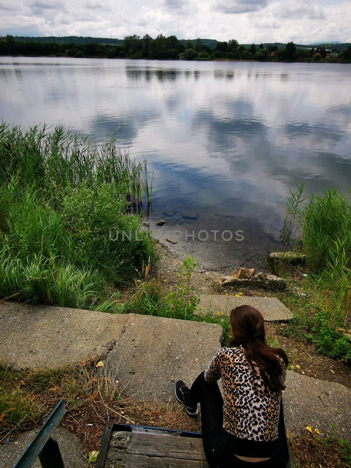 A woman standing in front of a body of water. High quality photo