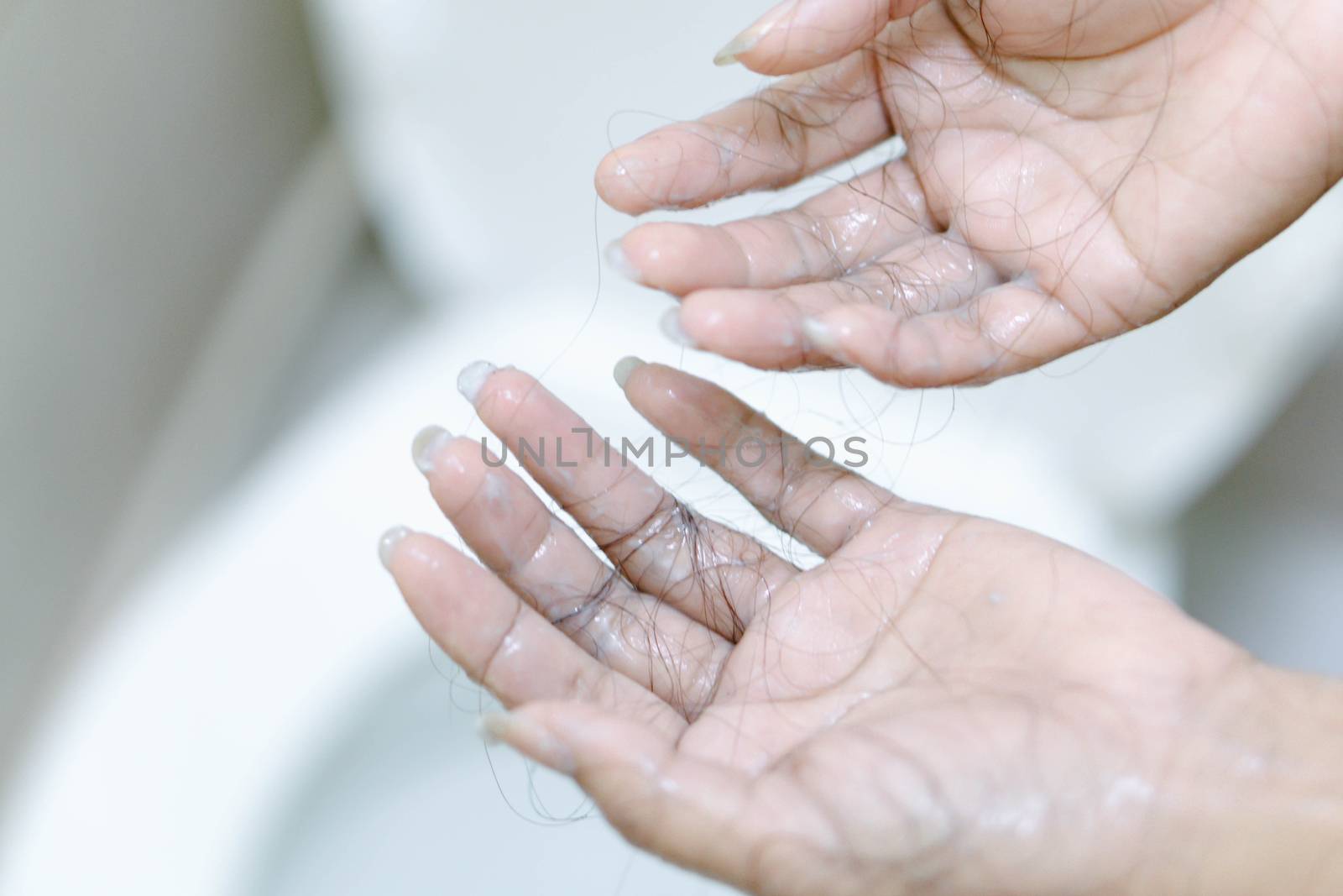 Closeup Hair loss on woman hand in the bathroom by pt.pongsak@gmail.com