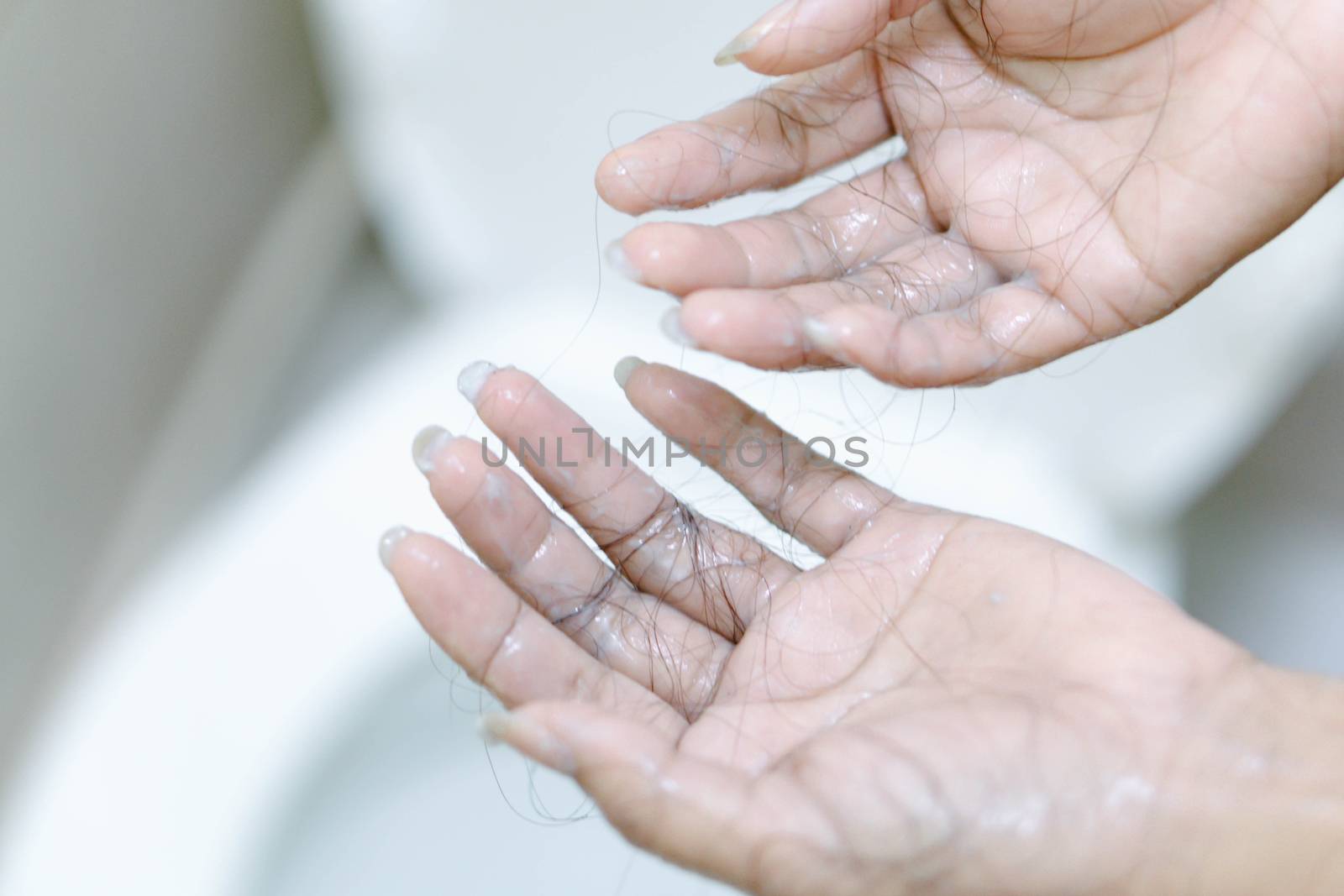 Closeup Hair loss on woman hand in the bathroom