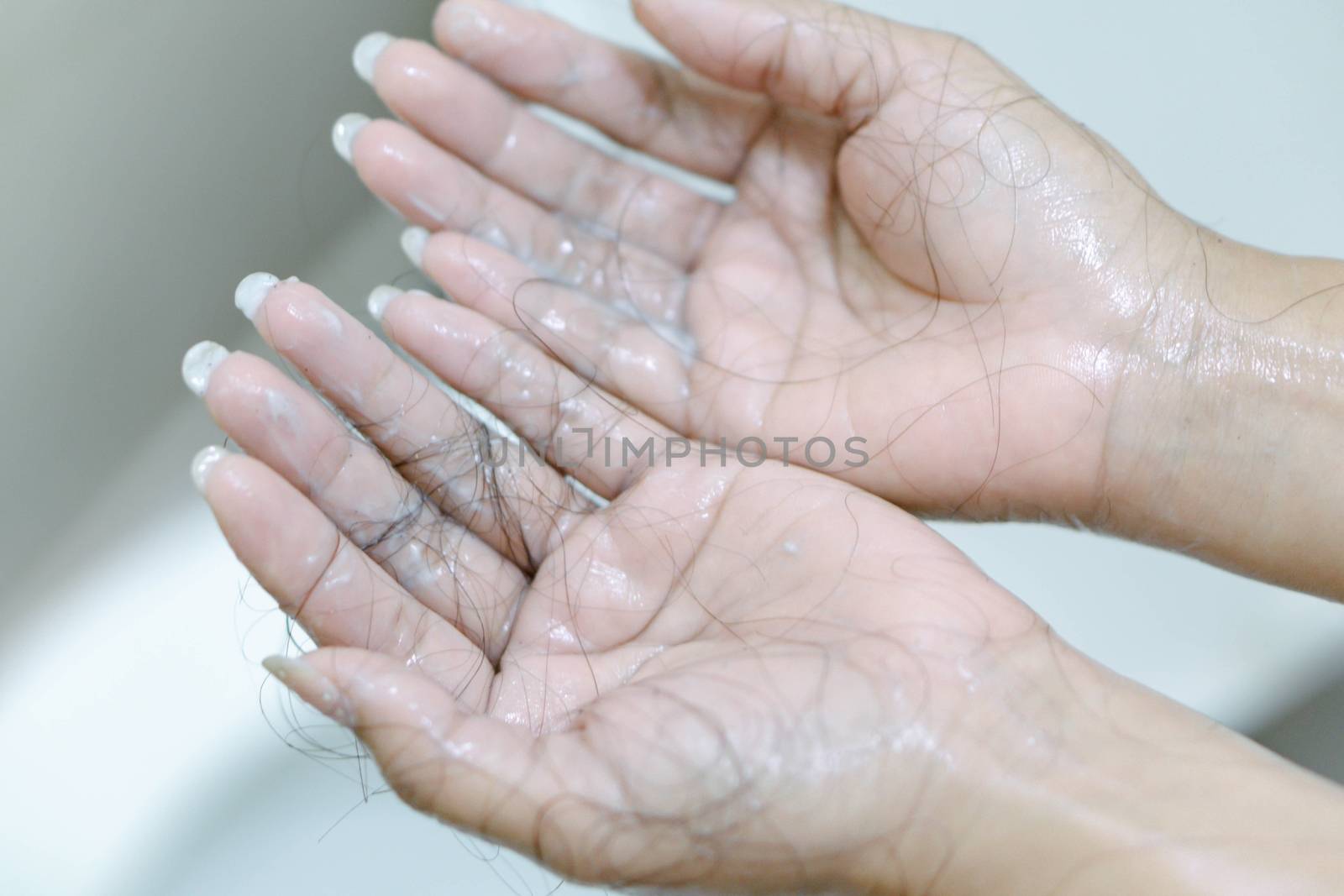 Closeup Hair loss on woman hand in the bathroom by pt.pongsak@gmail.com