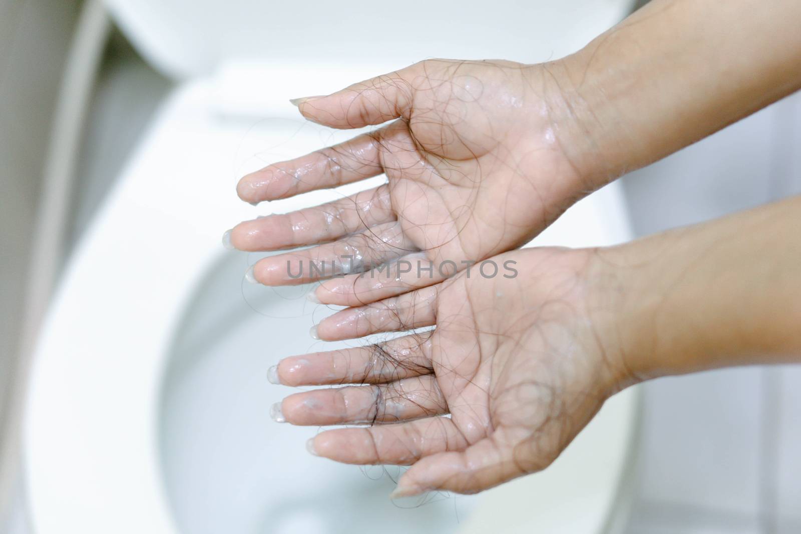 Closeup Hair loss on woman hand in the bathroom