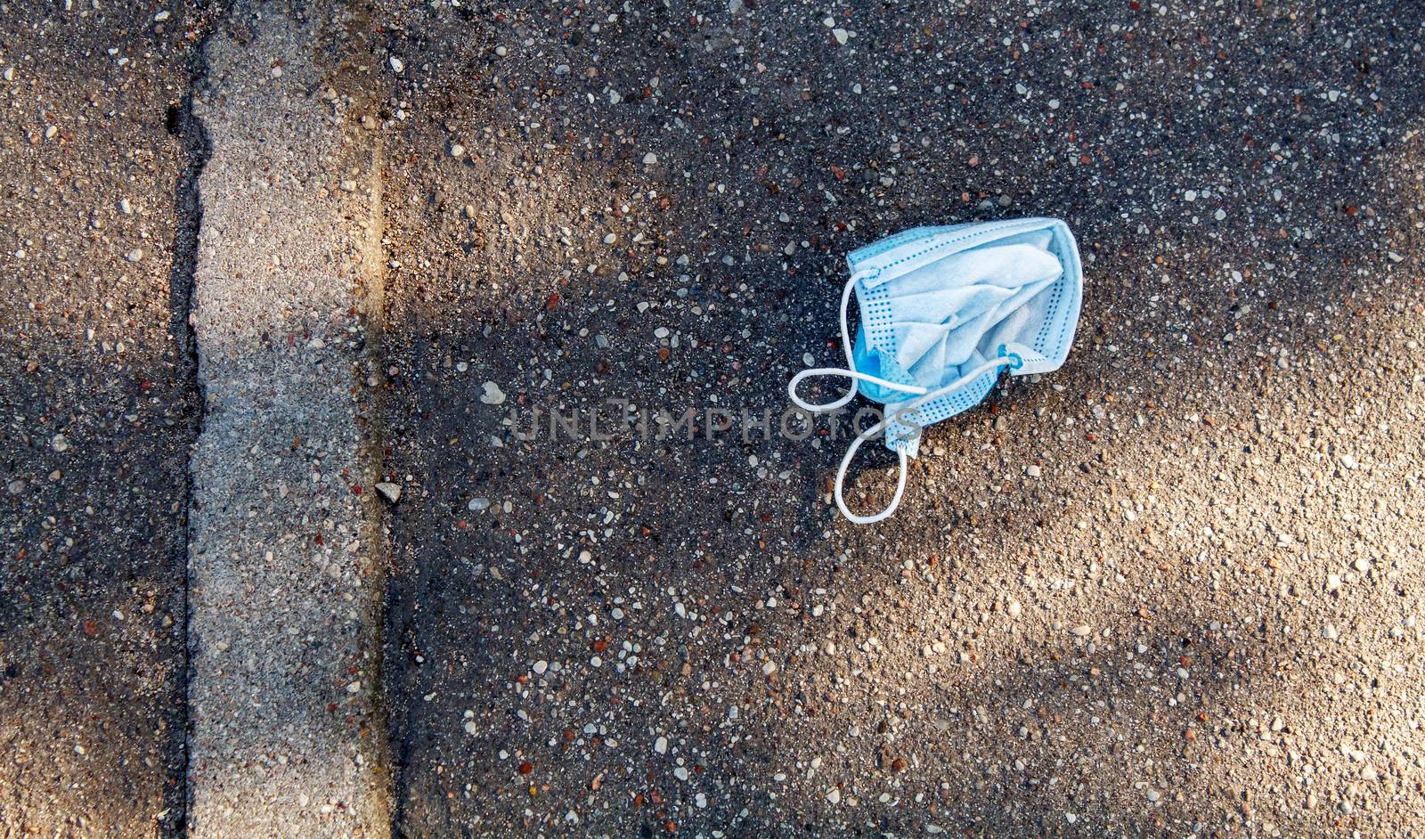 protective medical mask on the sidewalk on summer day