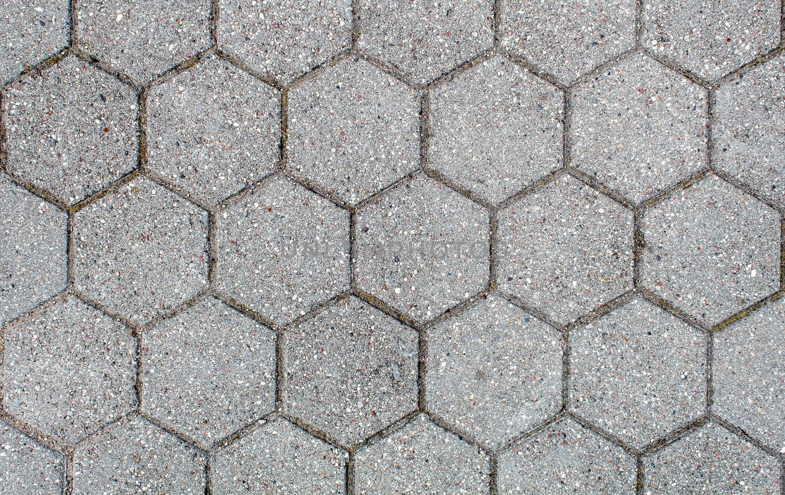 road paved with hexagonal sidewalk tiles. beautiful brick background with, masonry texture of light gray bricks. outdoor closeup