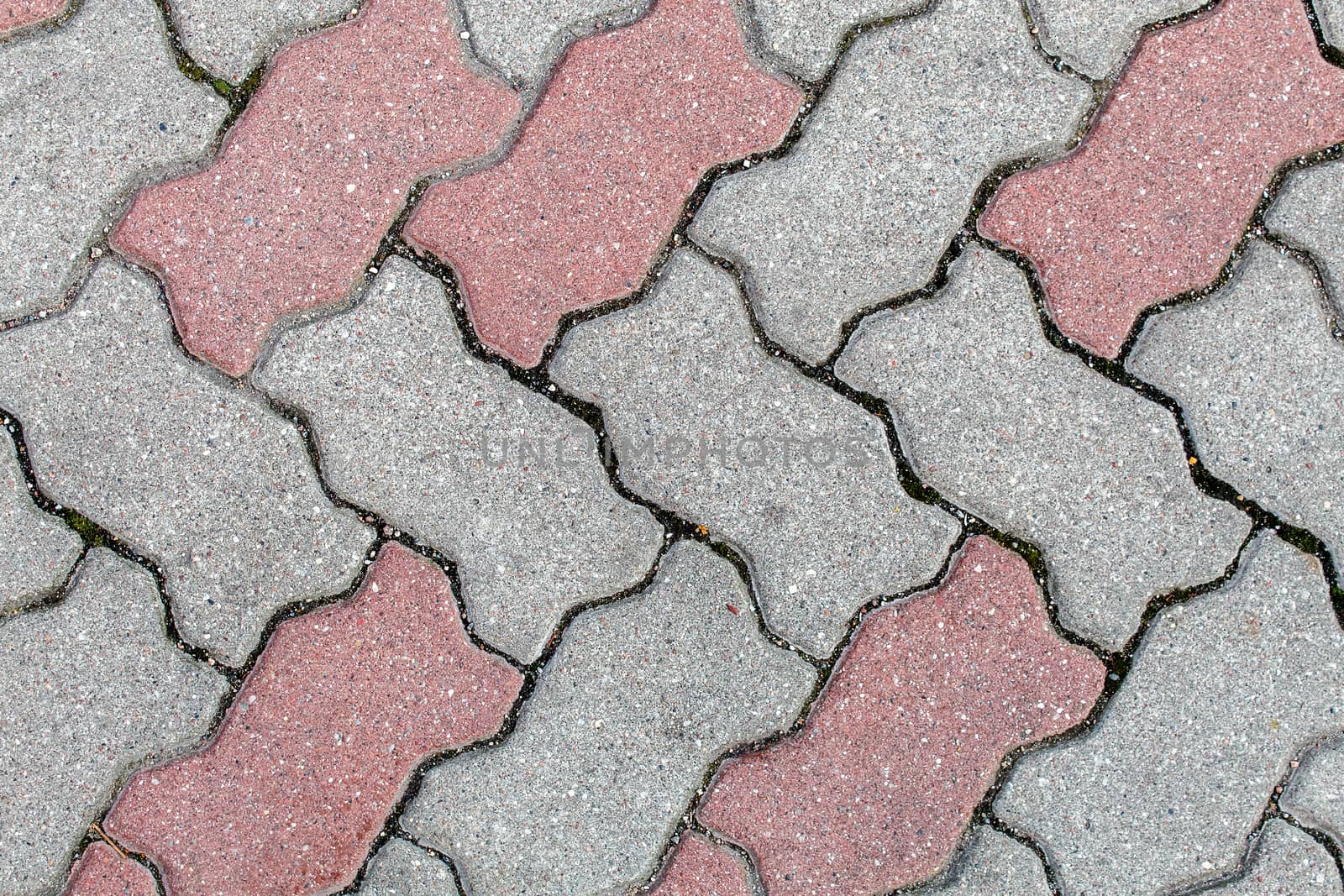 road paved with sidewalk tiles. beautiful brick background with, masonry texture of light brown and gray bricks. outdoor closeup