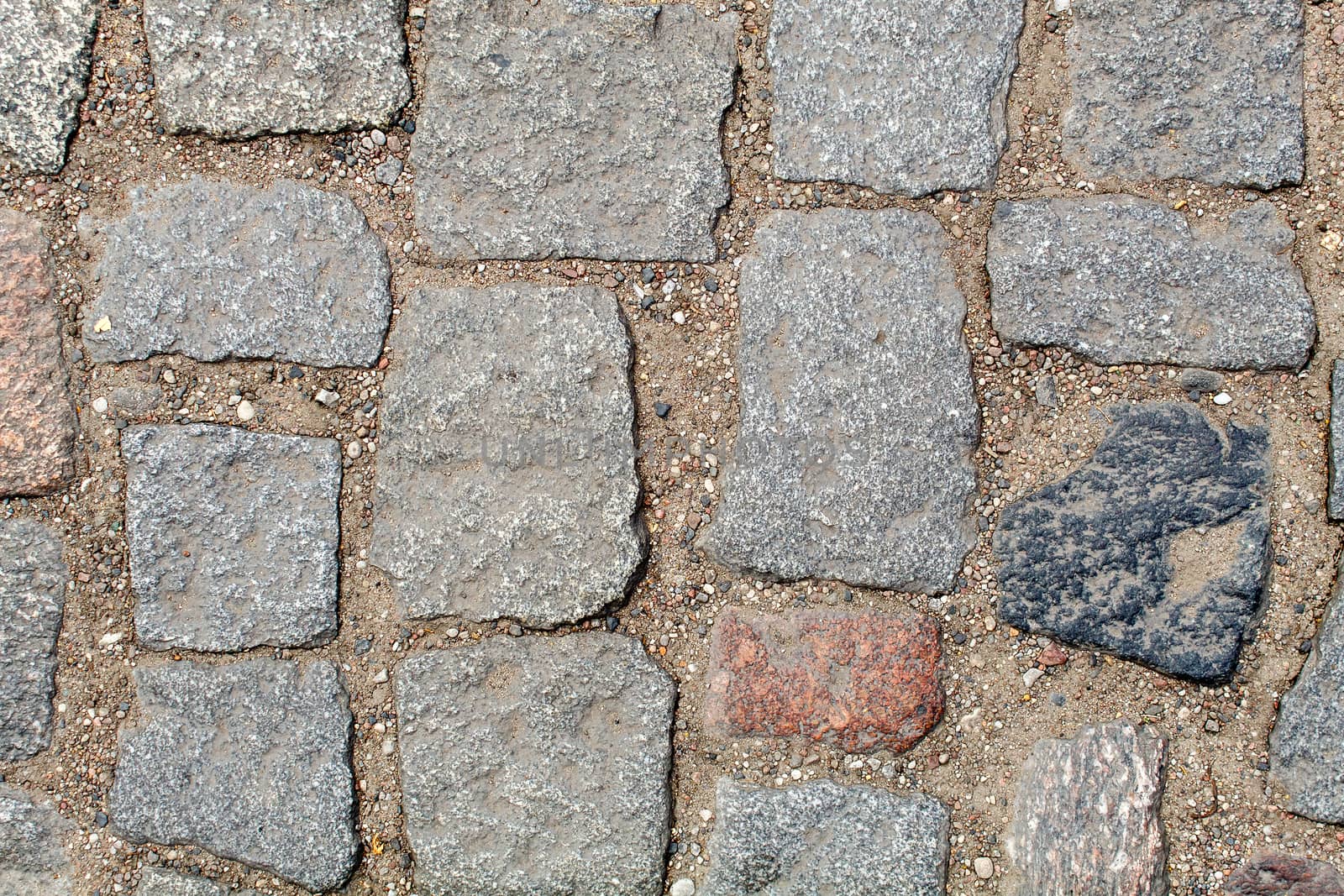 pavement of granite stone.old cobblestone road pavement texture. absrtact background. outdoor closeup