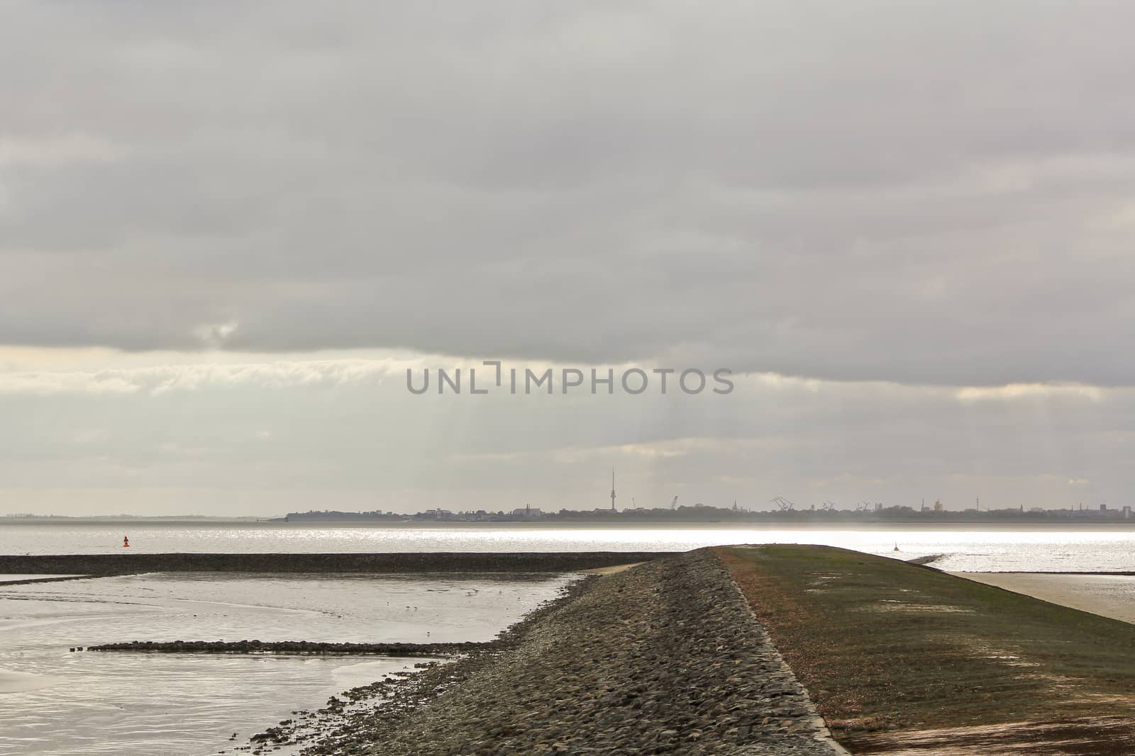 Water, clouds, dike shells on north German coast of Butjardingen. by Arkadij