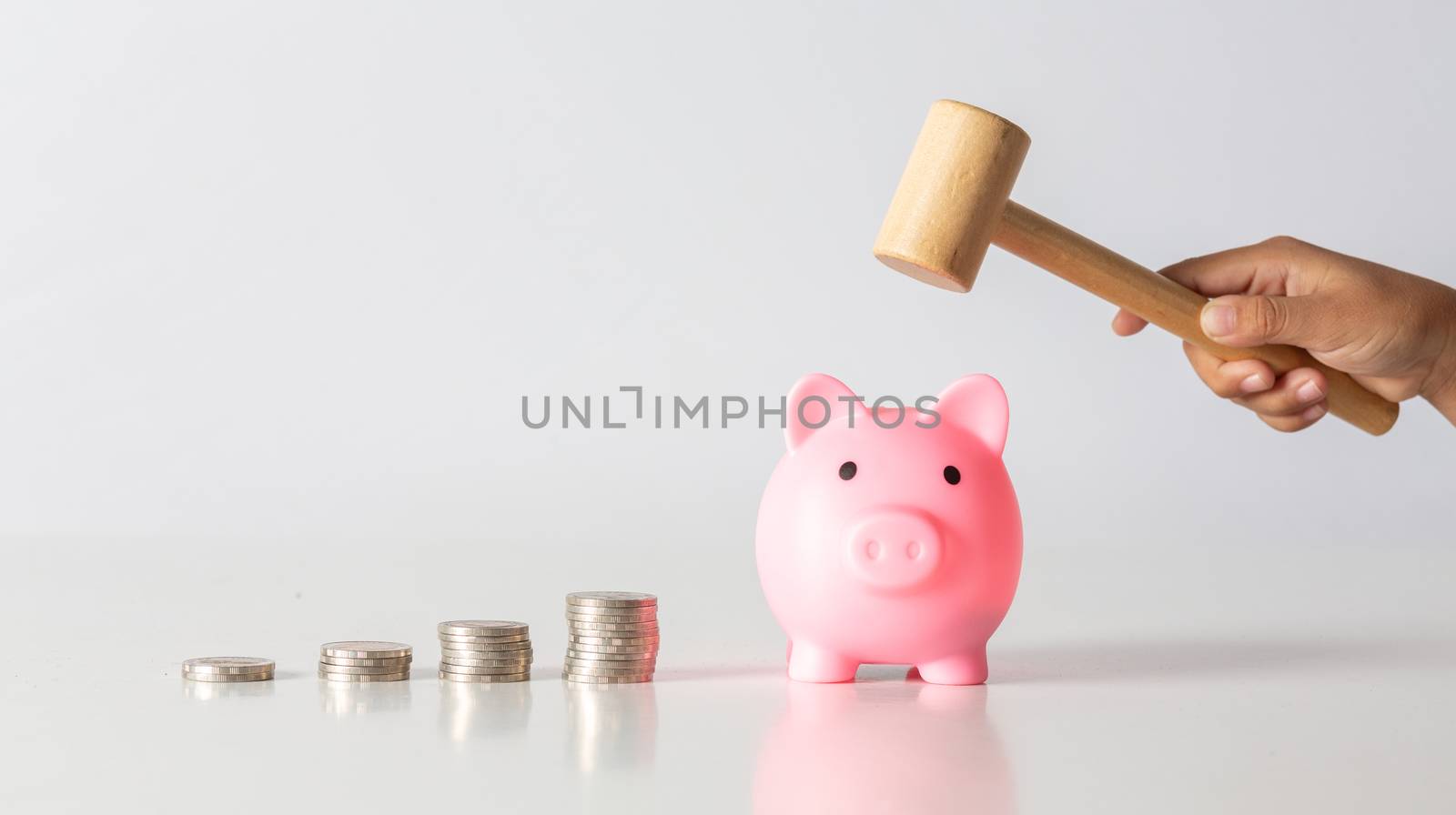 Hand of kid holding coin put in piggy bank with money stack grow by golfmhee