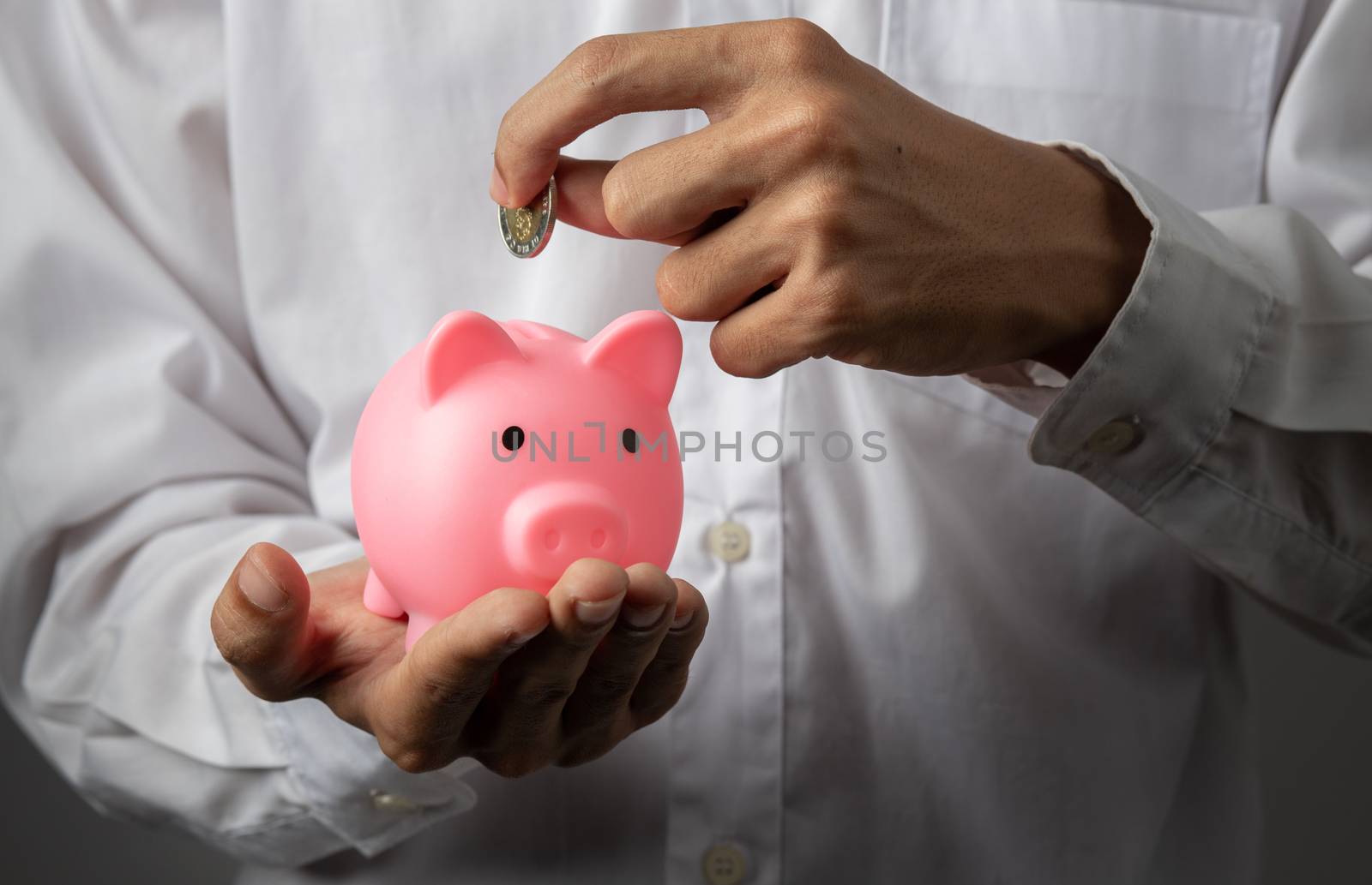 Hand of kid holding coin put in piggy bank with money stack grow by golfmhee