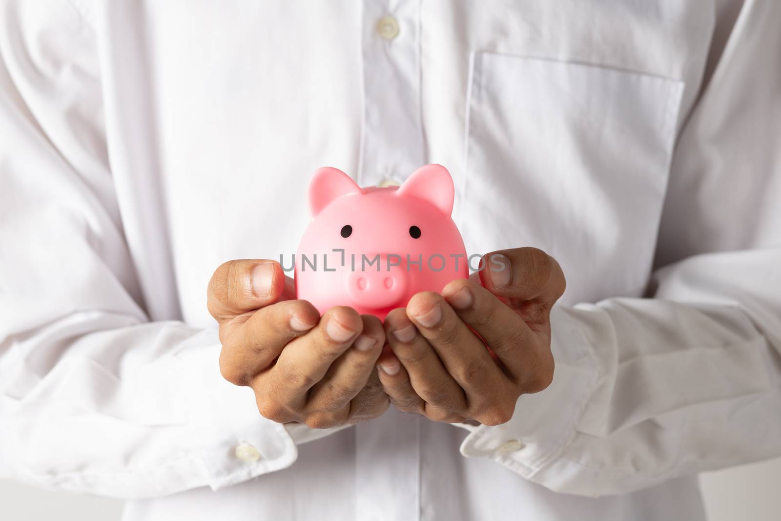 Hand of kid holding coin put in piggy bank with money stack grow by golfmhee