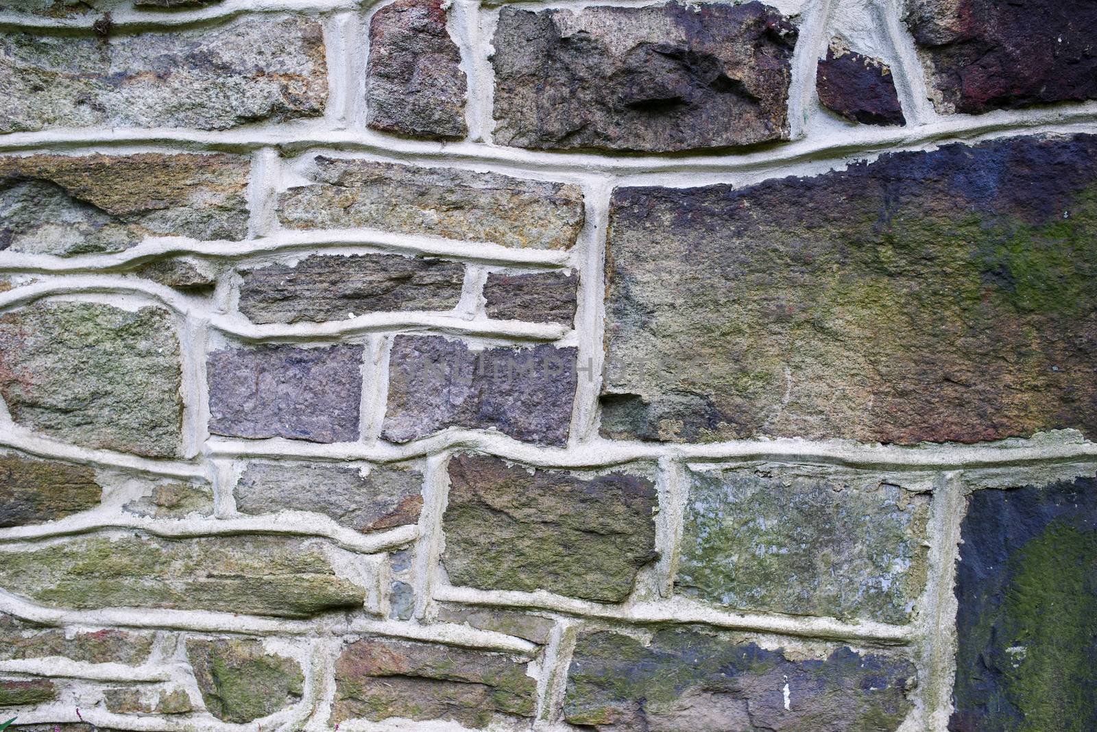 Pennsylvania farmhouse stone wall background. Vibrant purple, blue and green fieldstone, masonry texture, solid sturdy and reliable.