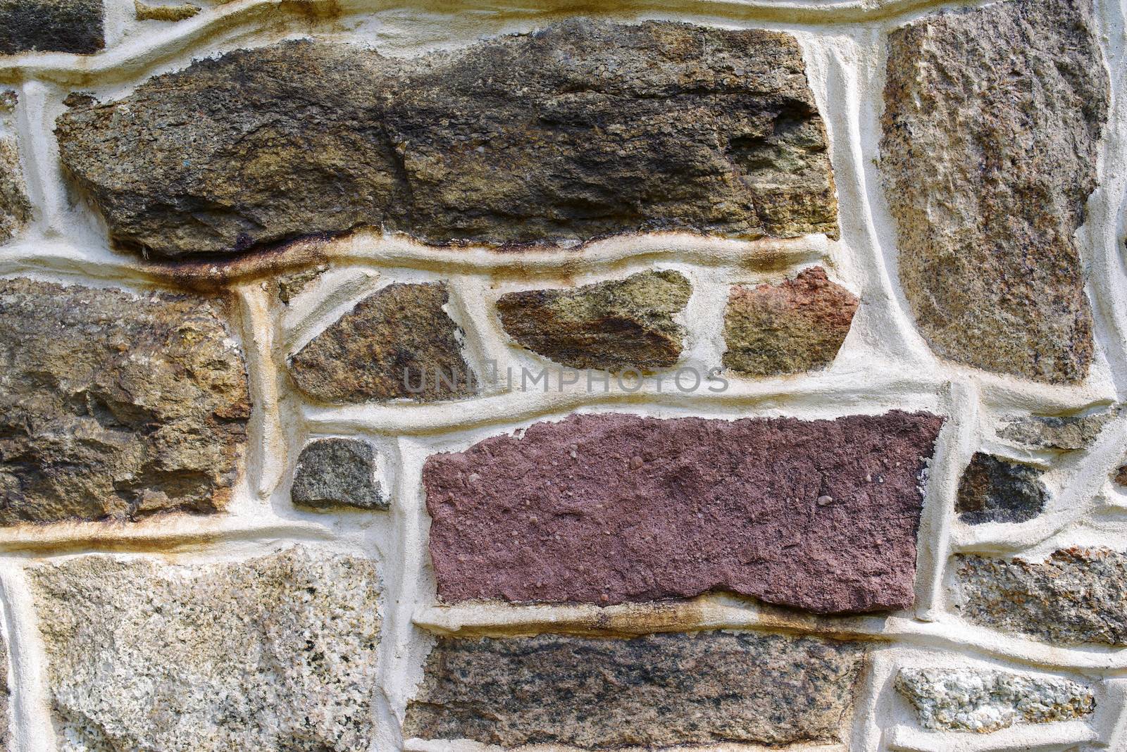 Old colorful fieldstone wall close up. by marysalen