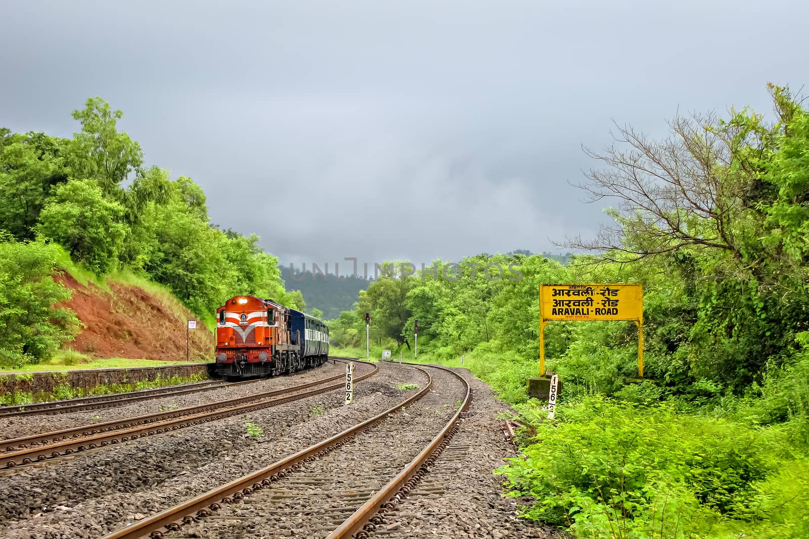 Indian Railway's passenger carrying train entering a beautiful, scenic station, by lalam