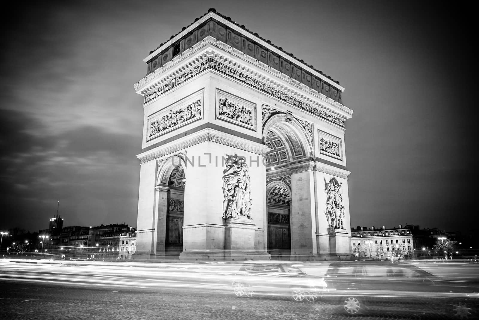 Rush hour traffic drives around the Arc de Triomphe in Paris, France