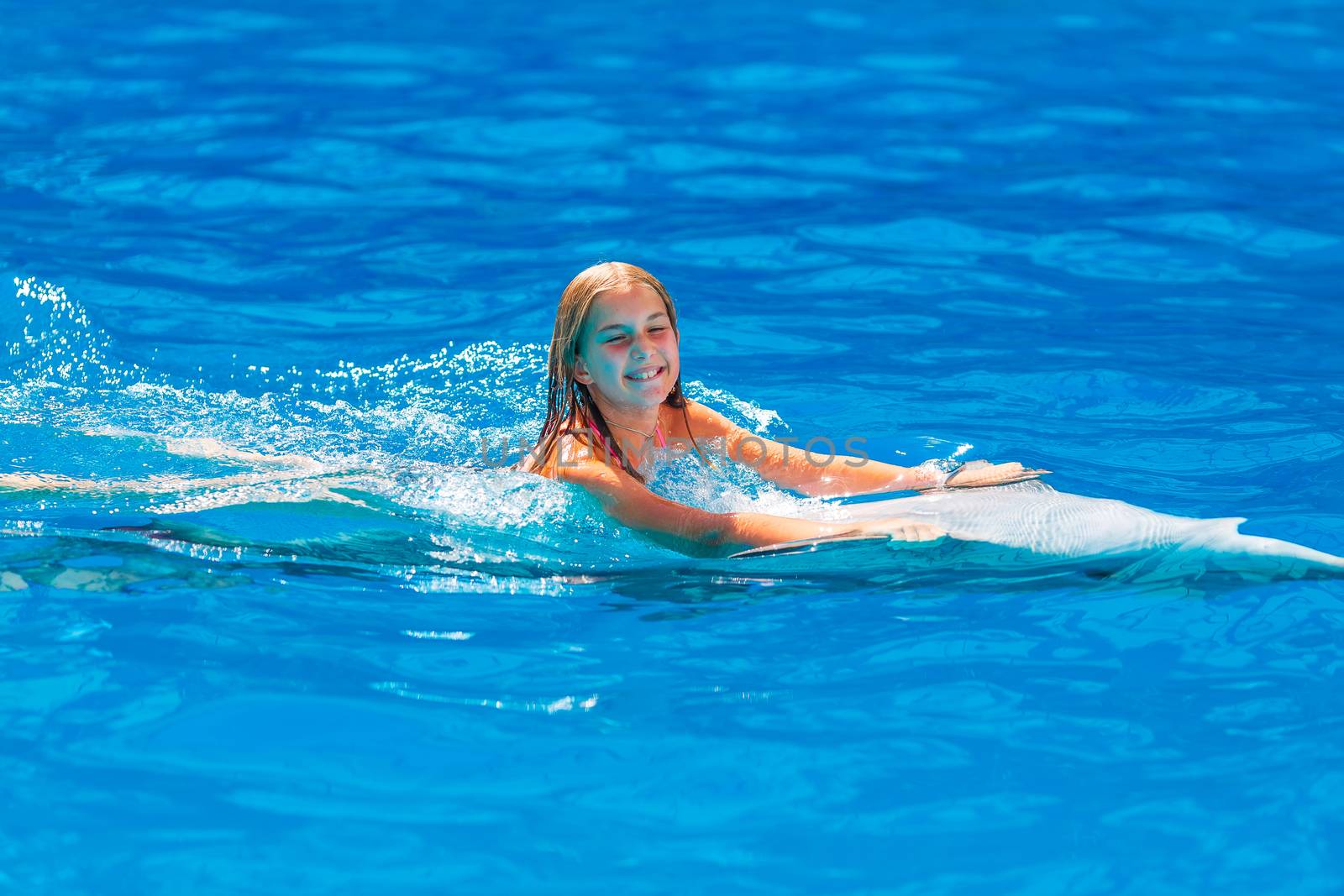 Happy little girl swimming with dolphins in Dolphinarium by Len44ik