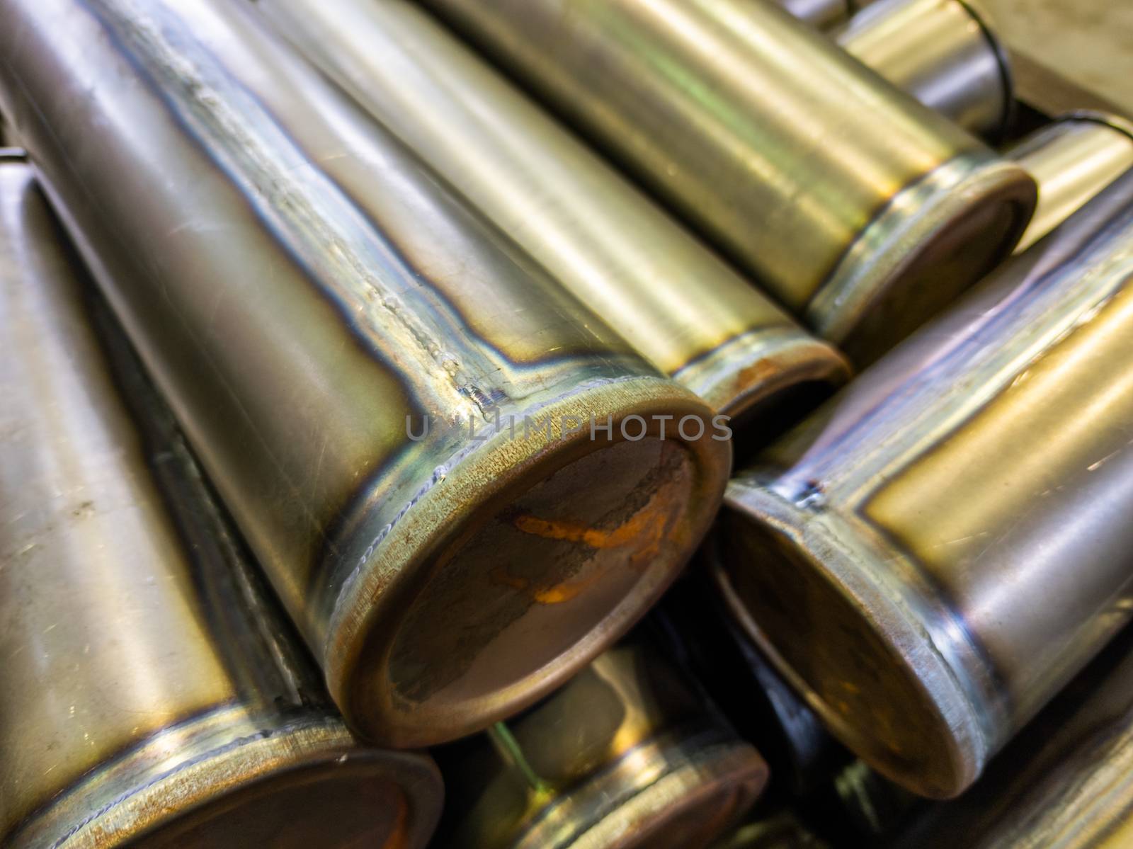 cylindrical steel tubes with tig argon arc welded seams - close-up industrial background with selective focus and blur.