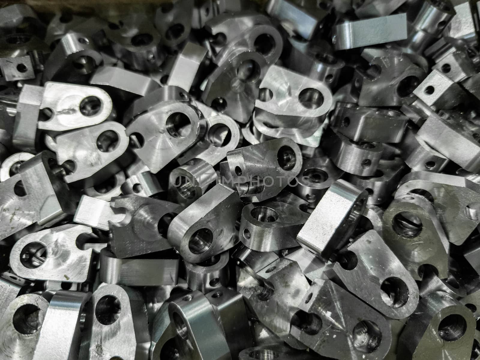 pile of shiny steel parts, full frame industrial background.