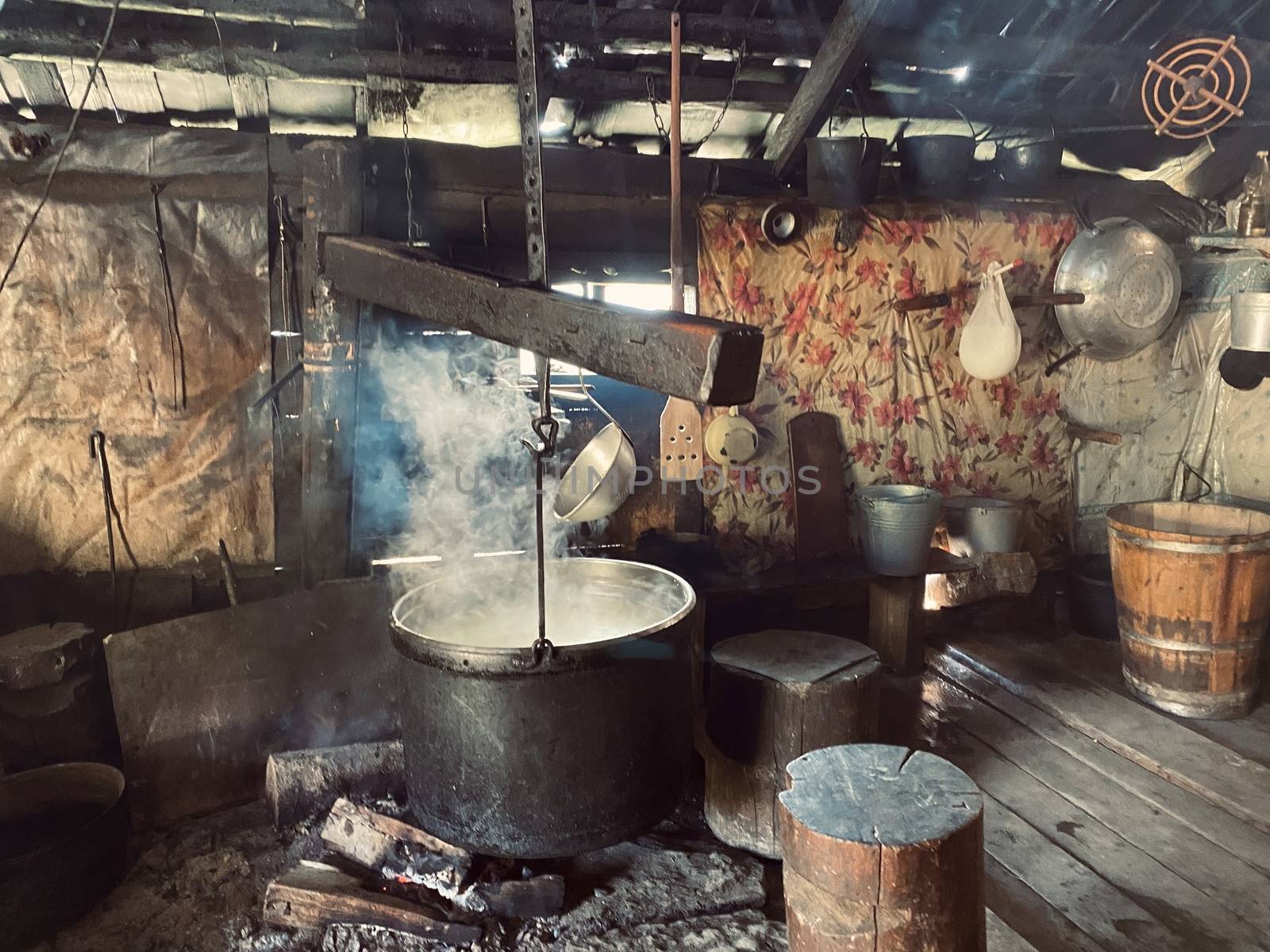 old vintage wooden house with bowler hat. iron pot, carpet in the hut. Living among nature