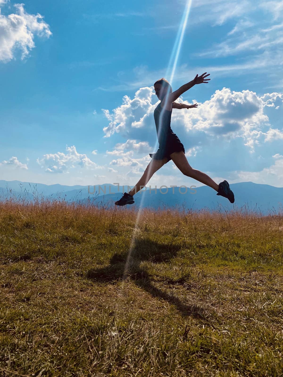 happy young woman jumping on the meadow