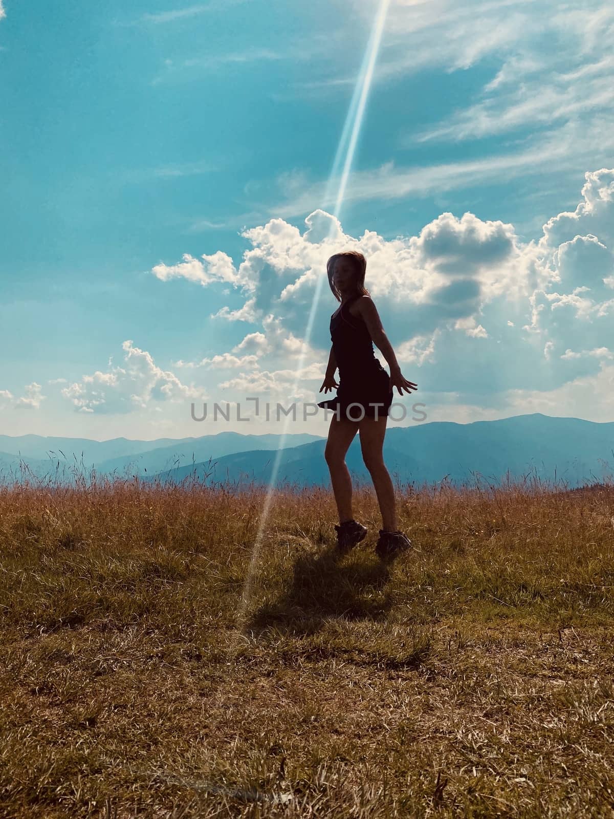 happy young woman jumping on the meadow