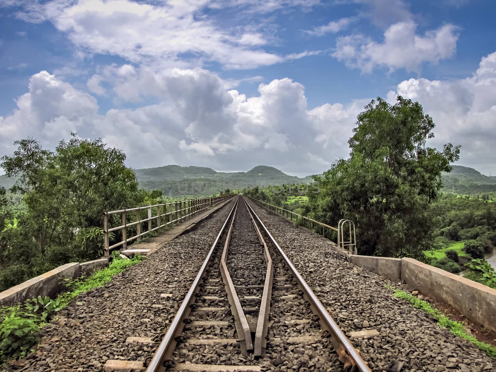 Converging rail track over bridge with nice blue sky and clouds background. by lalam