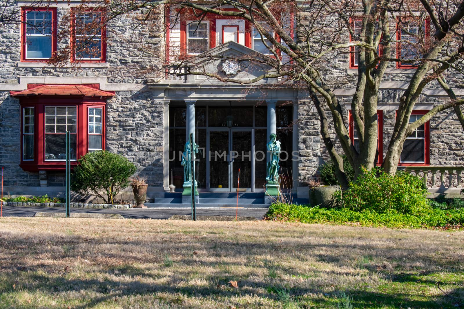 An Entrance to an Estate Like Home With a Statue on Each Side of the Door