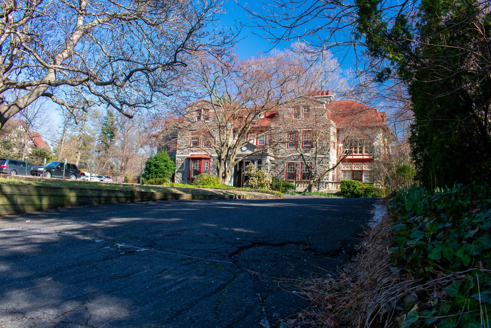 A Large Estate Like Property With a Large Driveway on a Clear Blue Sky