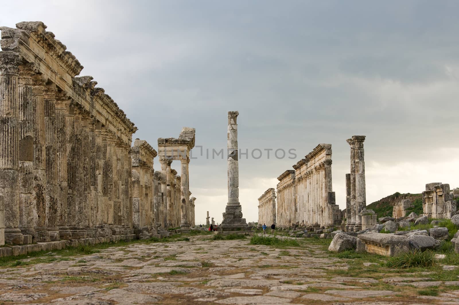 Apamea, Syria - May, 2009: Syria before the war. the Great Colonnade and triumphal arches in the impressive Apamea Greek and Roman city of Apamea in Syria. Apamea was an ancient Greek and Roman city on the banks of the Orontes River in Syria. The site includes the famous Great Colonnade, one of the longest in the world. As a result of the ongoing civil war in Syria that started in 2011, the Apamea ruins have been damaged and looted by treasure hunters.
