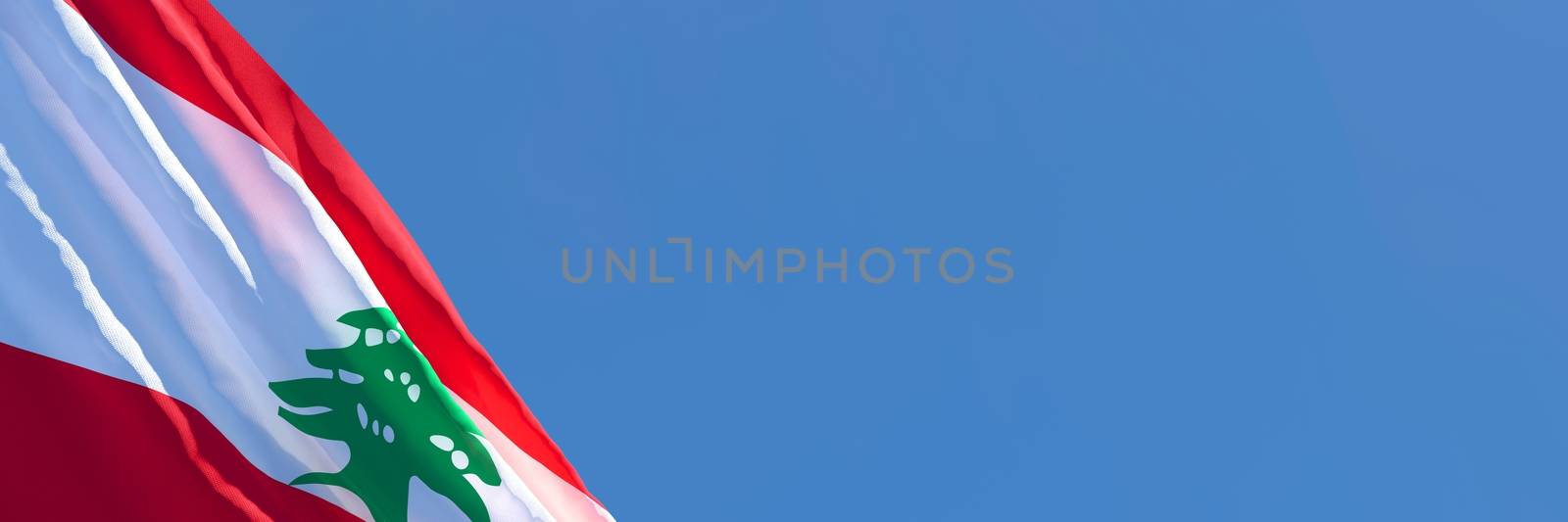 3D rendering of the national flag of Lebanon waving in the wind against a blue sky