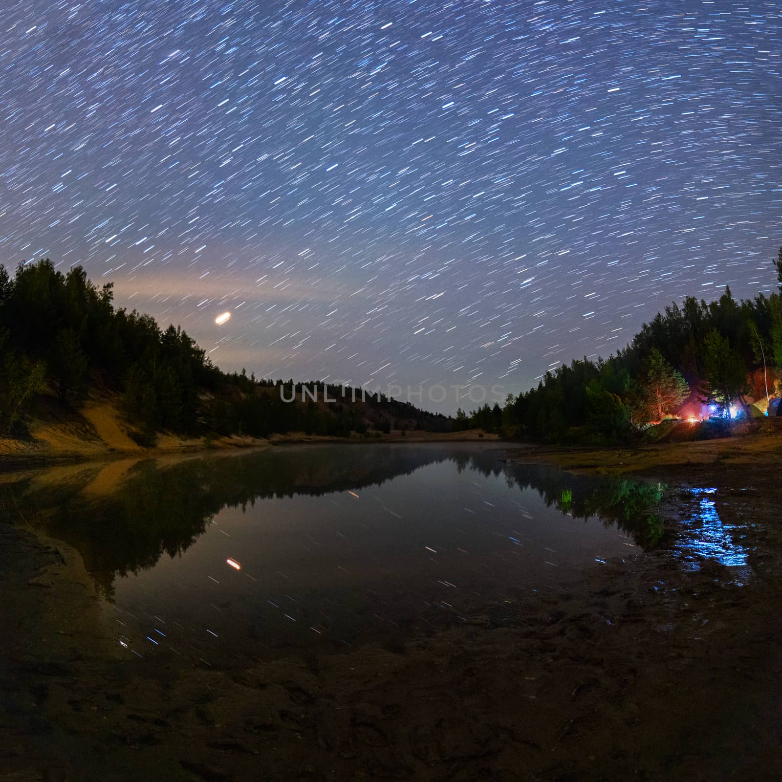 small lake under stars at night with short rails and camping at summer.
