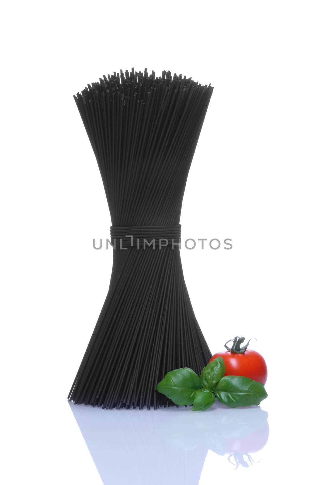 Black spaghetti with basel leaves and red tomato on white background.