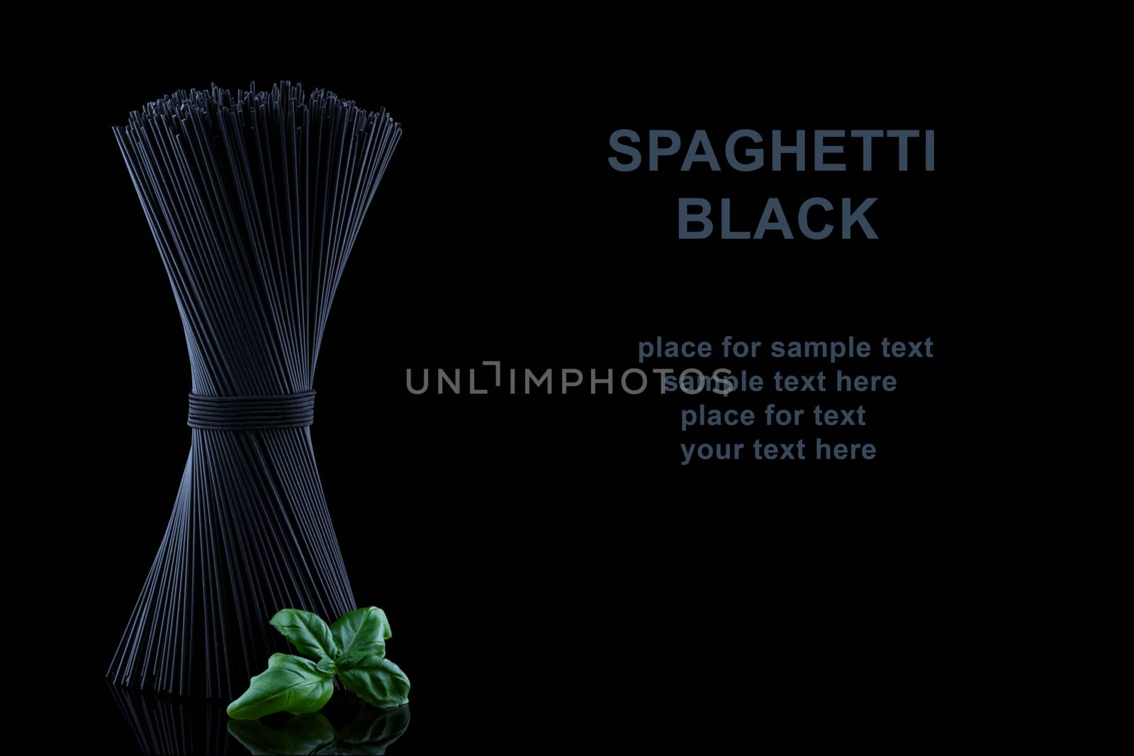 Black spaghetti with basel leaves on black background and place for text by Fischeron