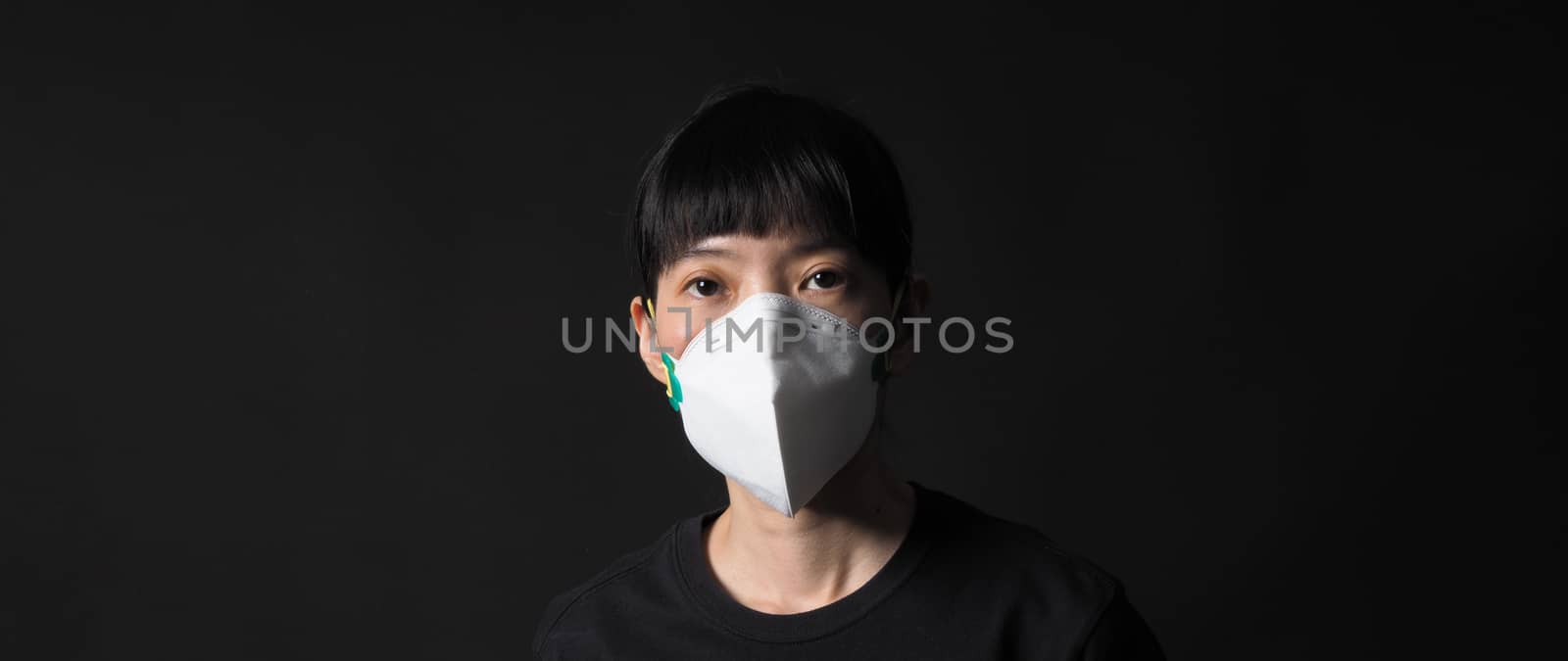 Middle aged of asia chinese woman wearing medical N95 mask that help prevent or protect her from coronavirus or covid-19 pandemic and safety from air pollution. and copy space