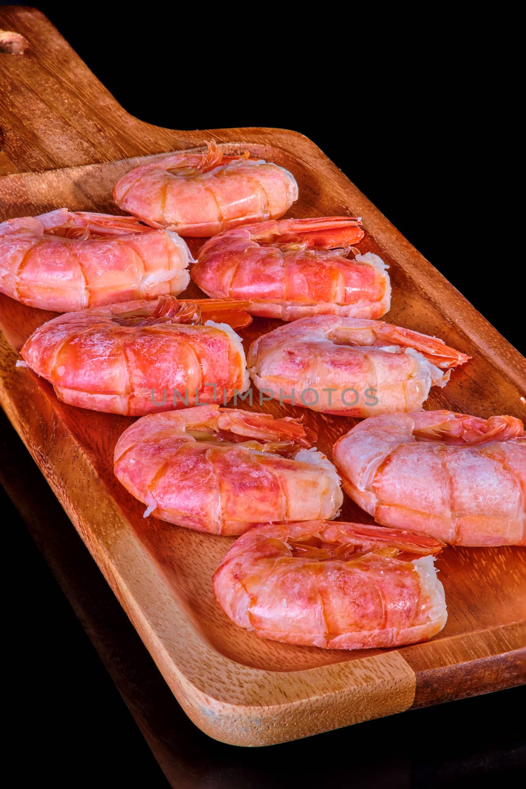 Healthy diet food: boiled wild tiger shrimps close-up on a plate on a table.