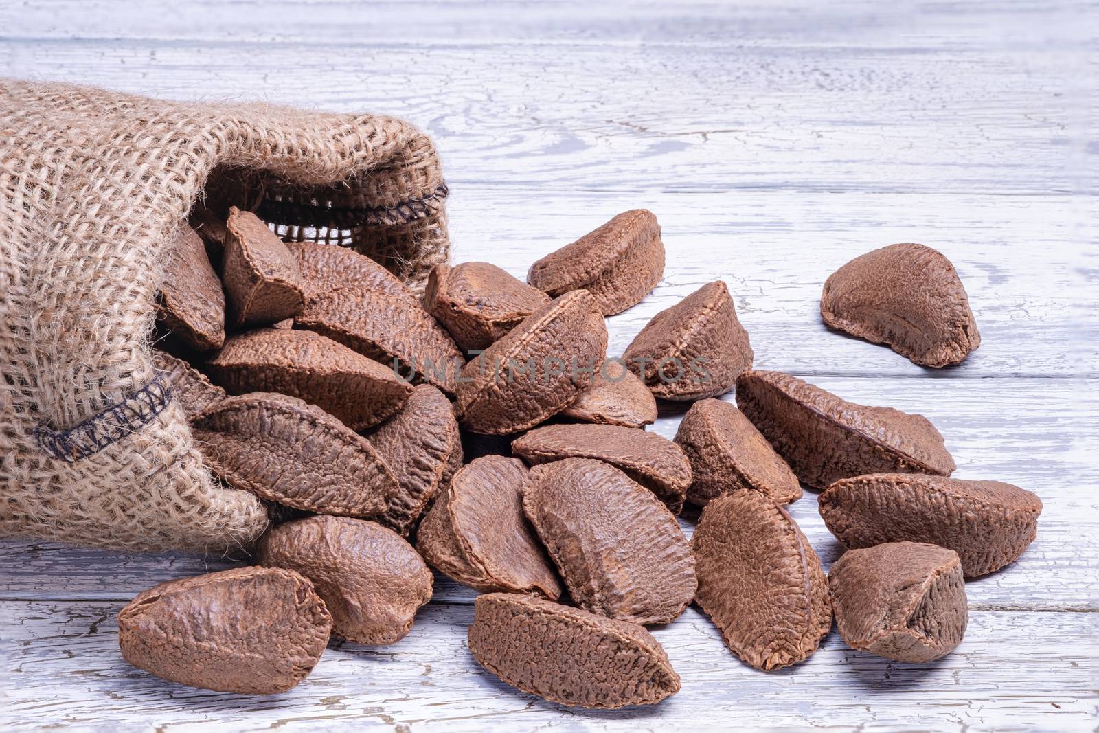 Paranuts in bag, vegetarian food in wooden bowls, on old wooden background.