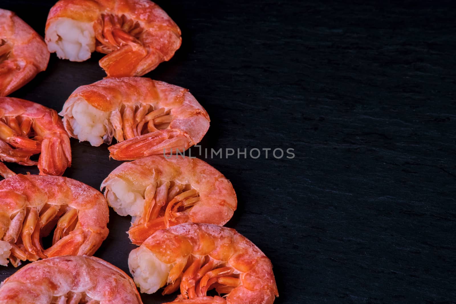 Healthy diet food: boiled wild tiger shrimps close-up on a plate on a table.