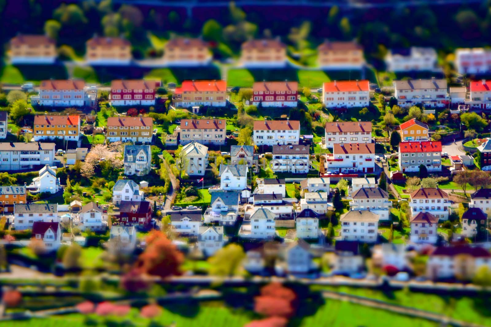 Tilt-shift creative image of an upper-class residential city suburb district with houses and gardens. Miniature effect