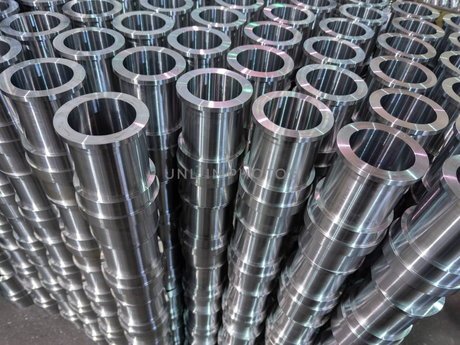 abstract industrial shiny steel production stack background with cnc machined pipes - selective focus and lens blur technique. View from above.