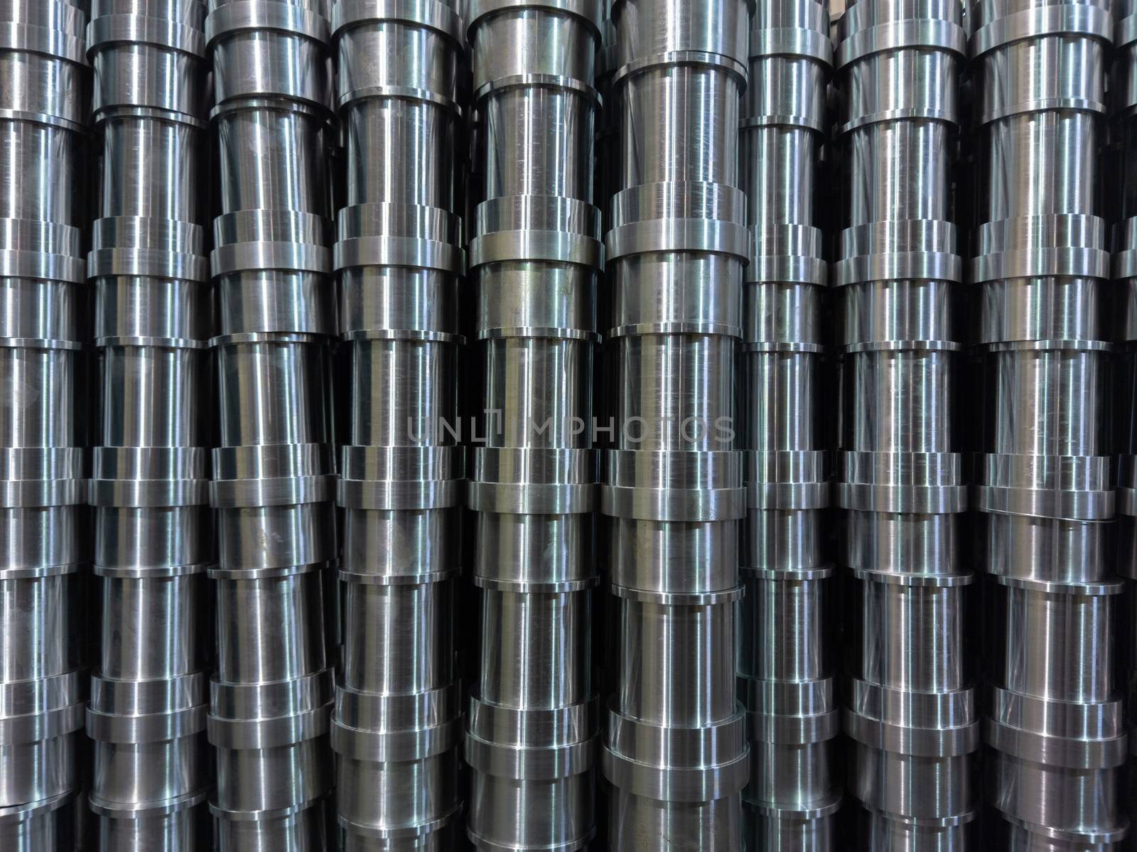 abstract industrial shiny steel production stack full frame background with cnc machined pipes - selective focus and lens blur technique. Side full frame view.